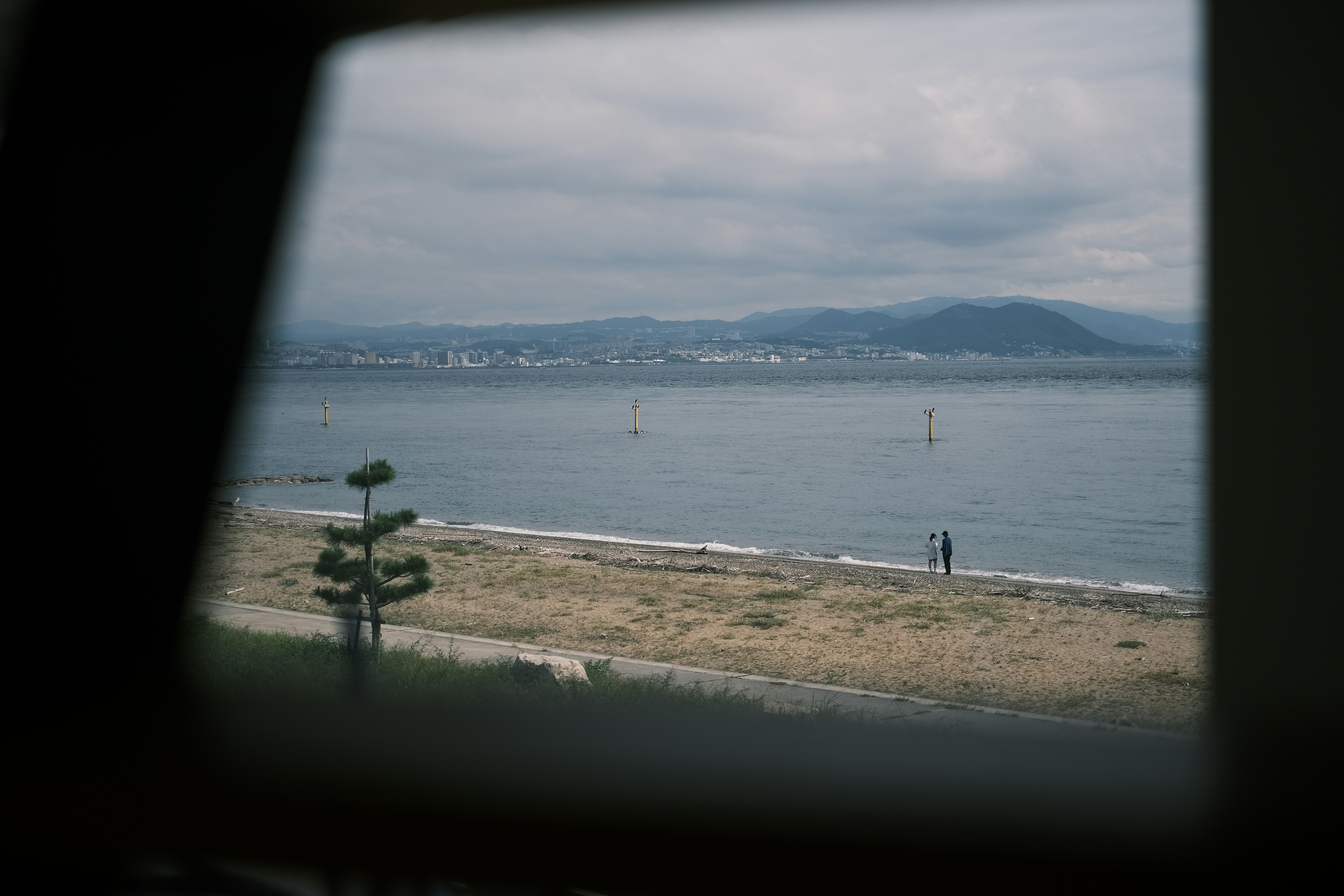 窓の切り欠き越しに広がる海辺の風景