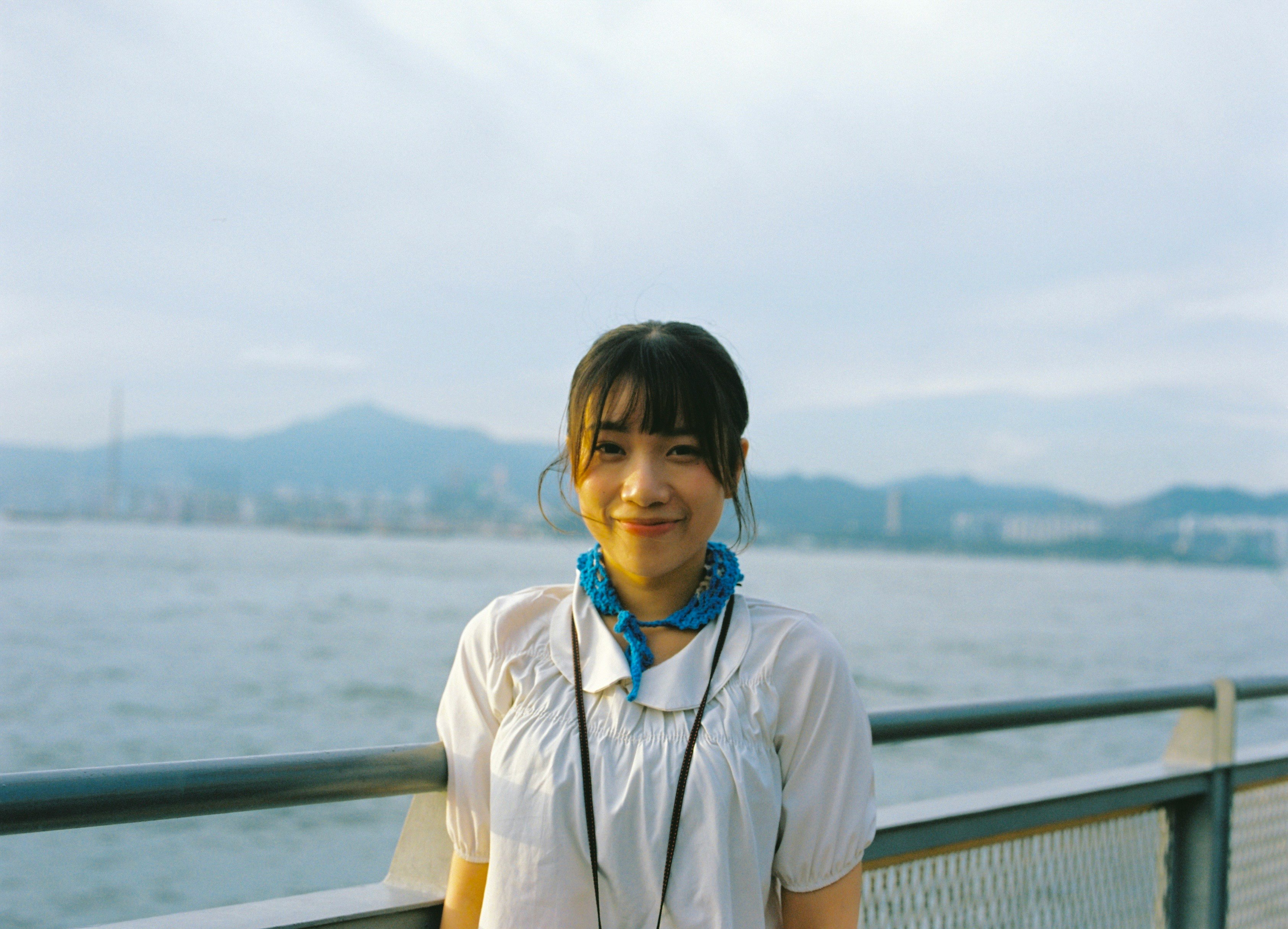 海辺の展望デッキで微笑む女性