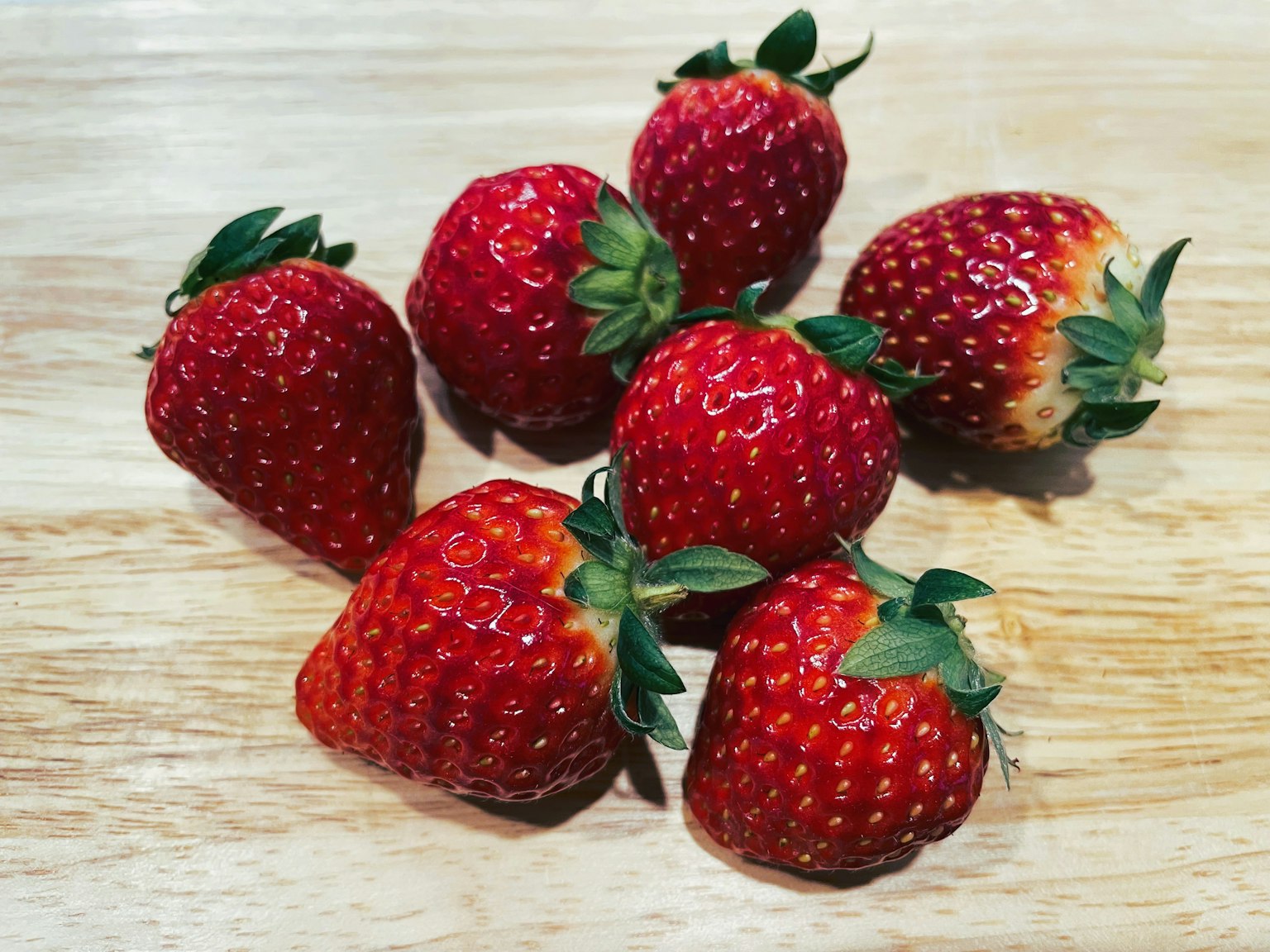 Fresh strawberries arranged on a wooden table