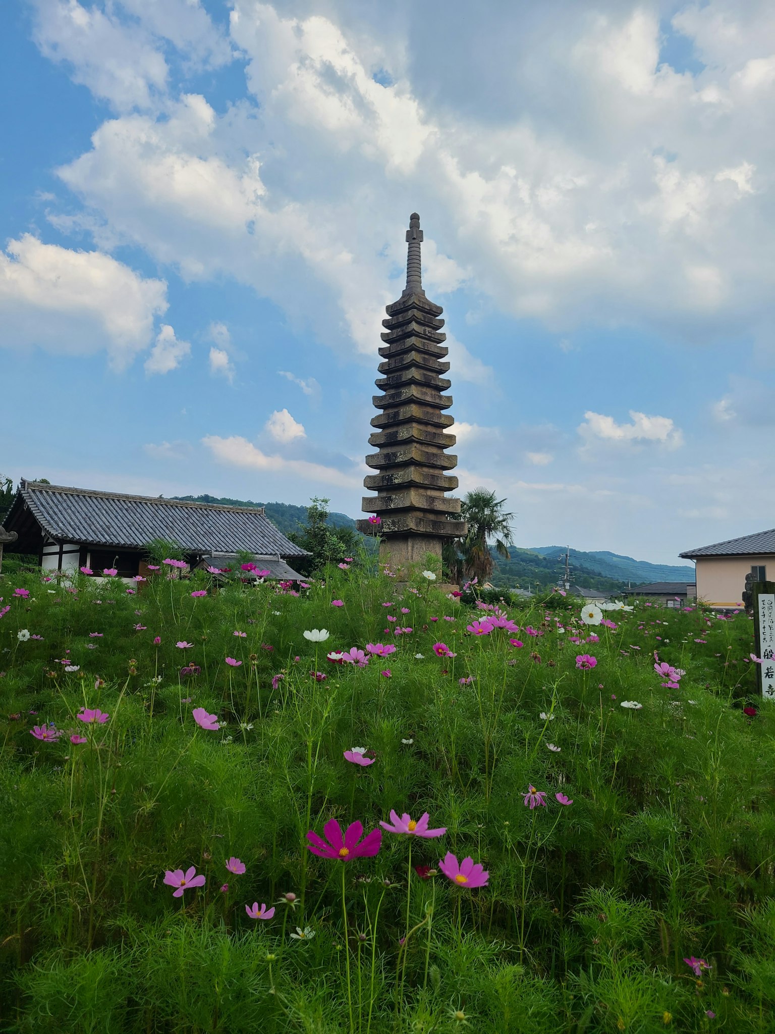 Une pagode majestueuse sous un ciel bleu magnifique entourée de fleurs colorées