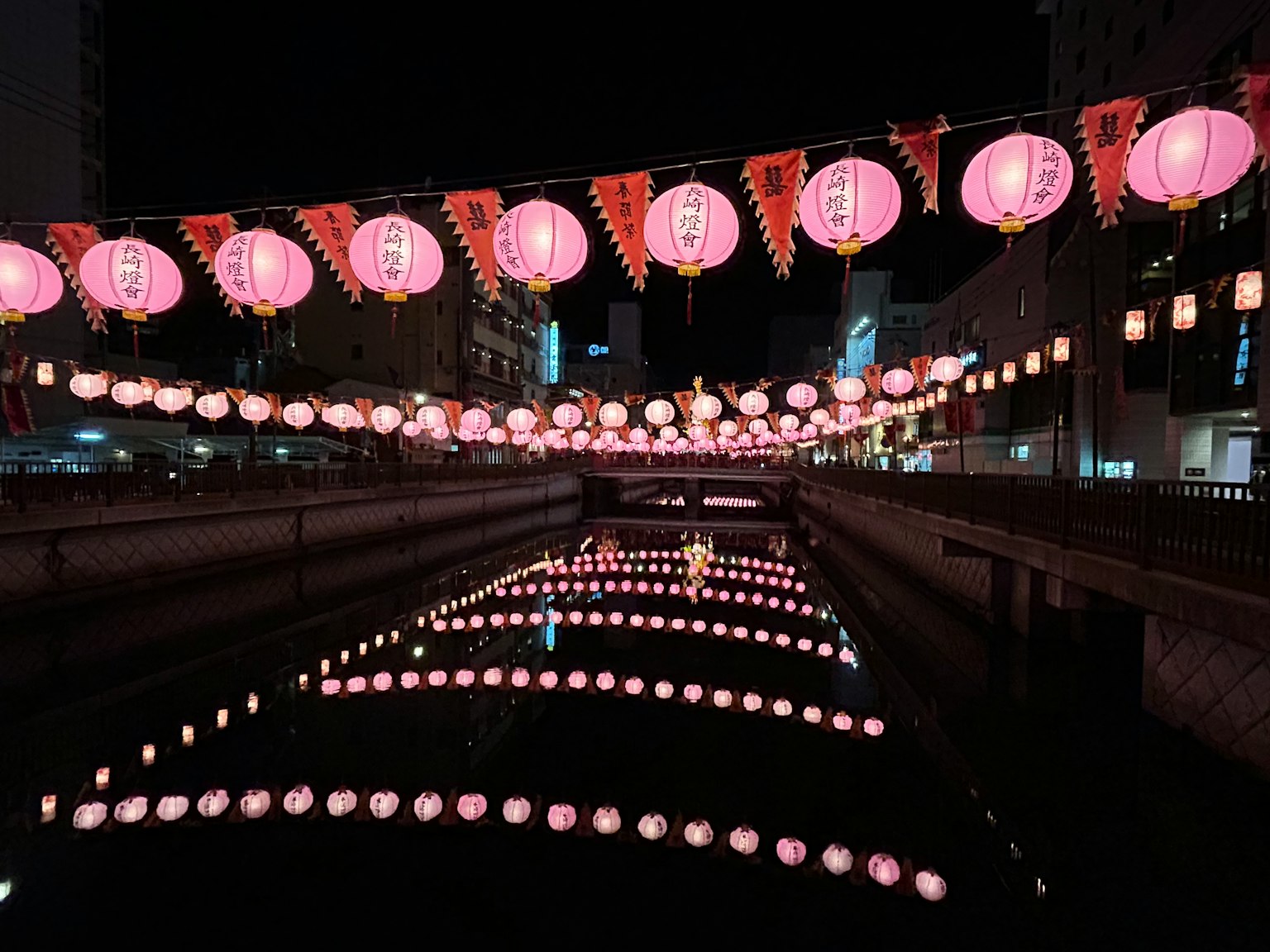 夜晚河上漂浮着粉色灯笼的美丽景象