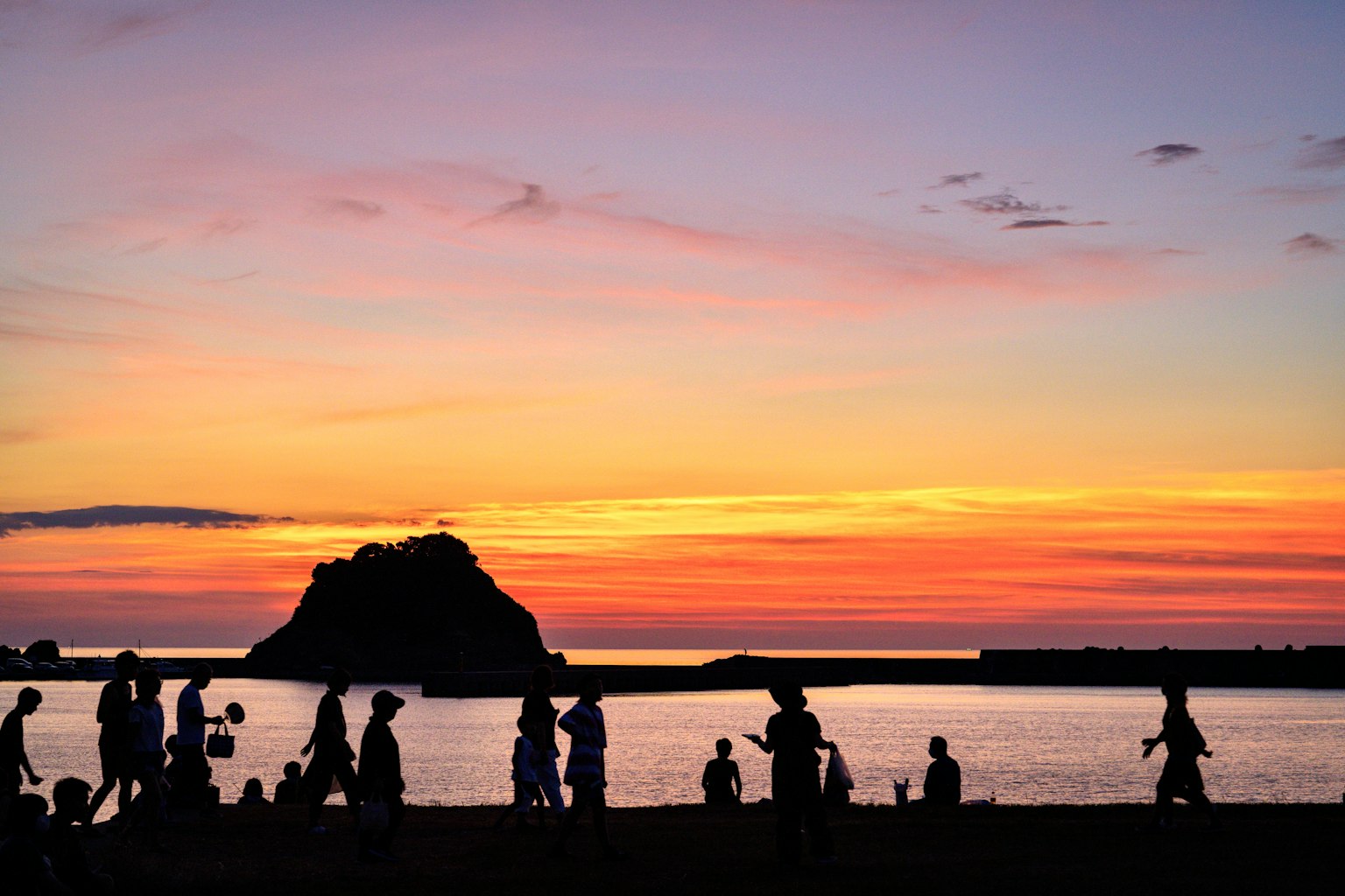 เงาคนที่มีพระอาทิตย์ตกดินและเกาะอยู่ด้านหลัง