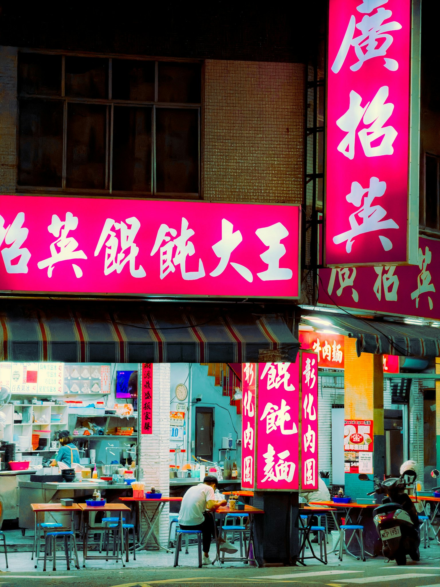 Abendliche Street-Food-Läden mit leuchtend roten Schildern image