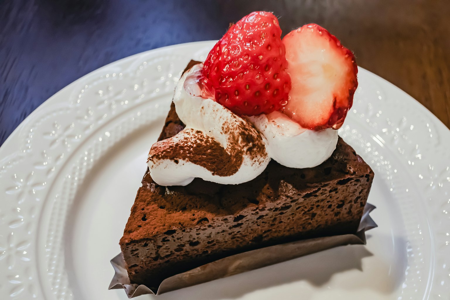 Chocolate cake topped with whipped cream and strawberries