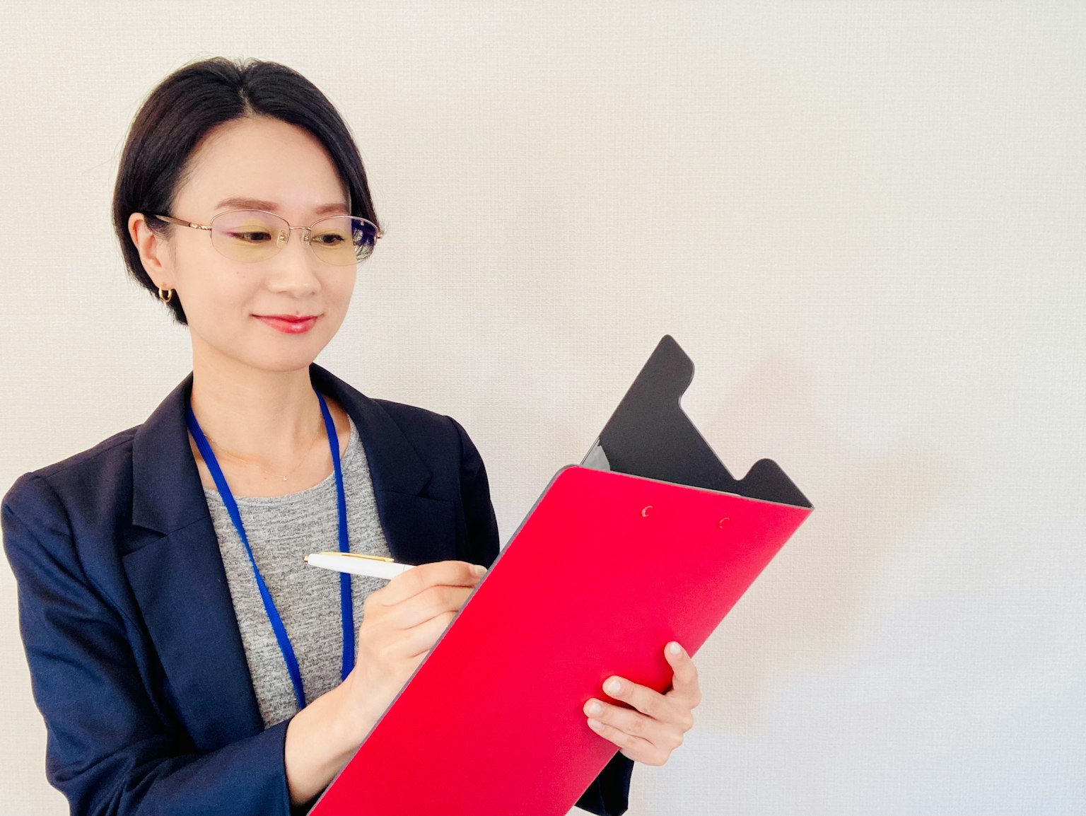Woman holding a red clipboard taking notes