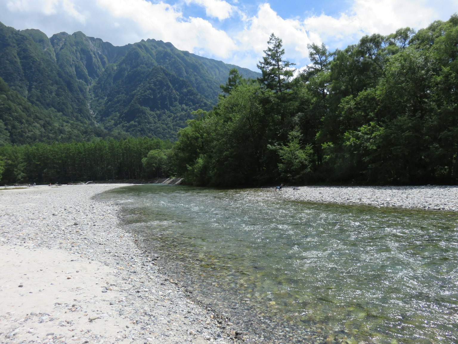 Pemandangan sungai yang indah dikelilingi pegunungan dan kehijauan yang subur