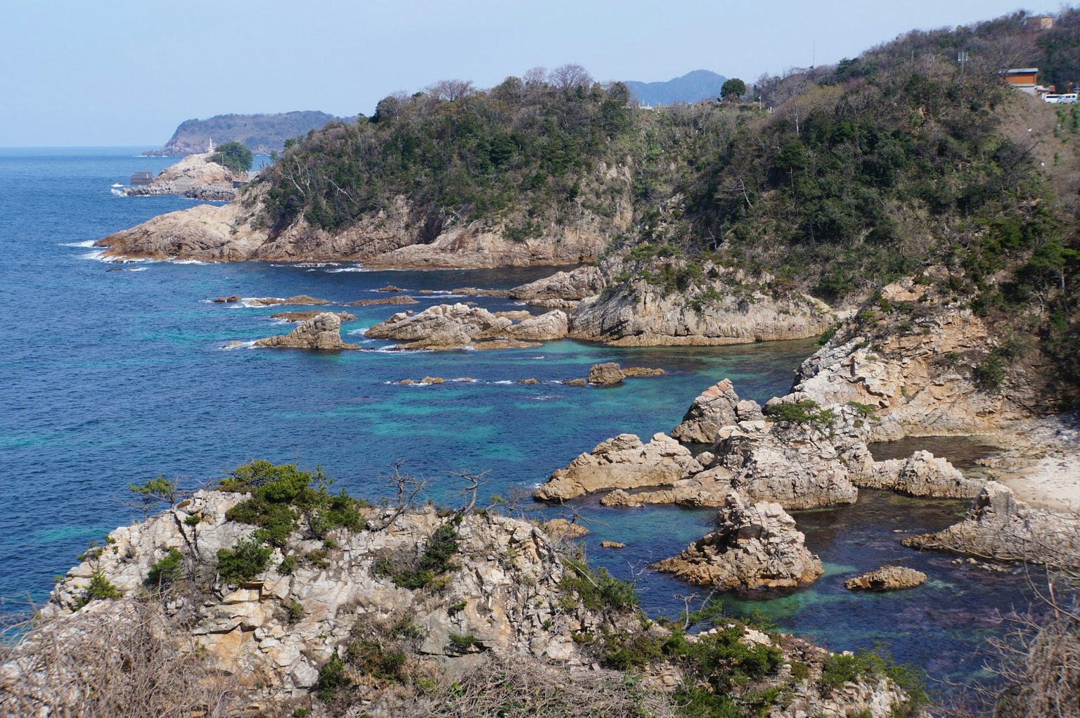 Bella costa con formazioni rocciose mare blu e vegetazione verde