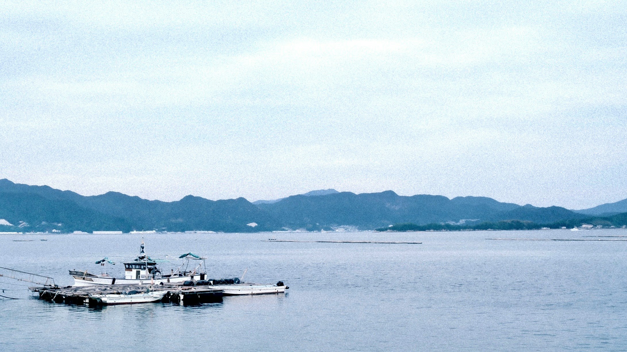 穏やかな海に浮かぶ桟橋と船