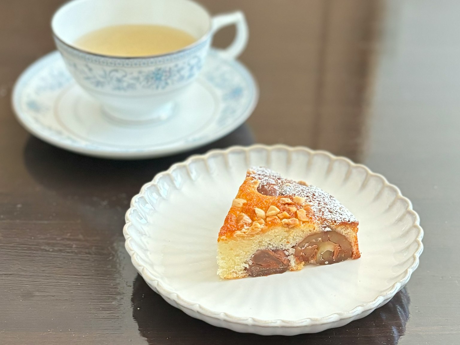 Miếng bánh trên đĩa với tách trà ở phía sau