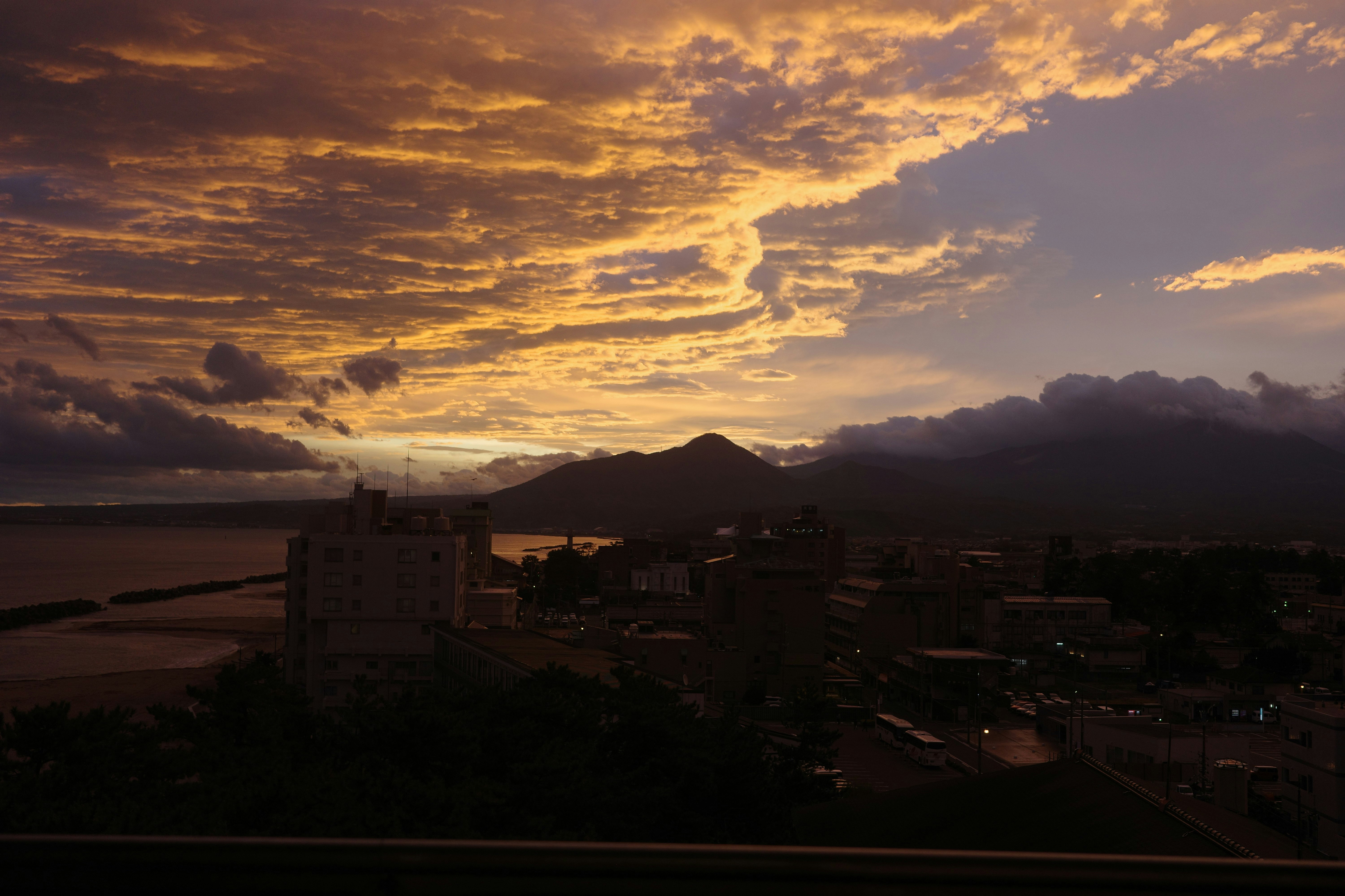 city view overlooking the seaside and mountain range at sunset