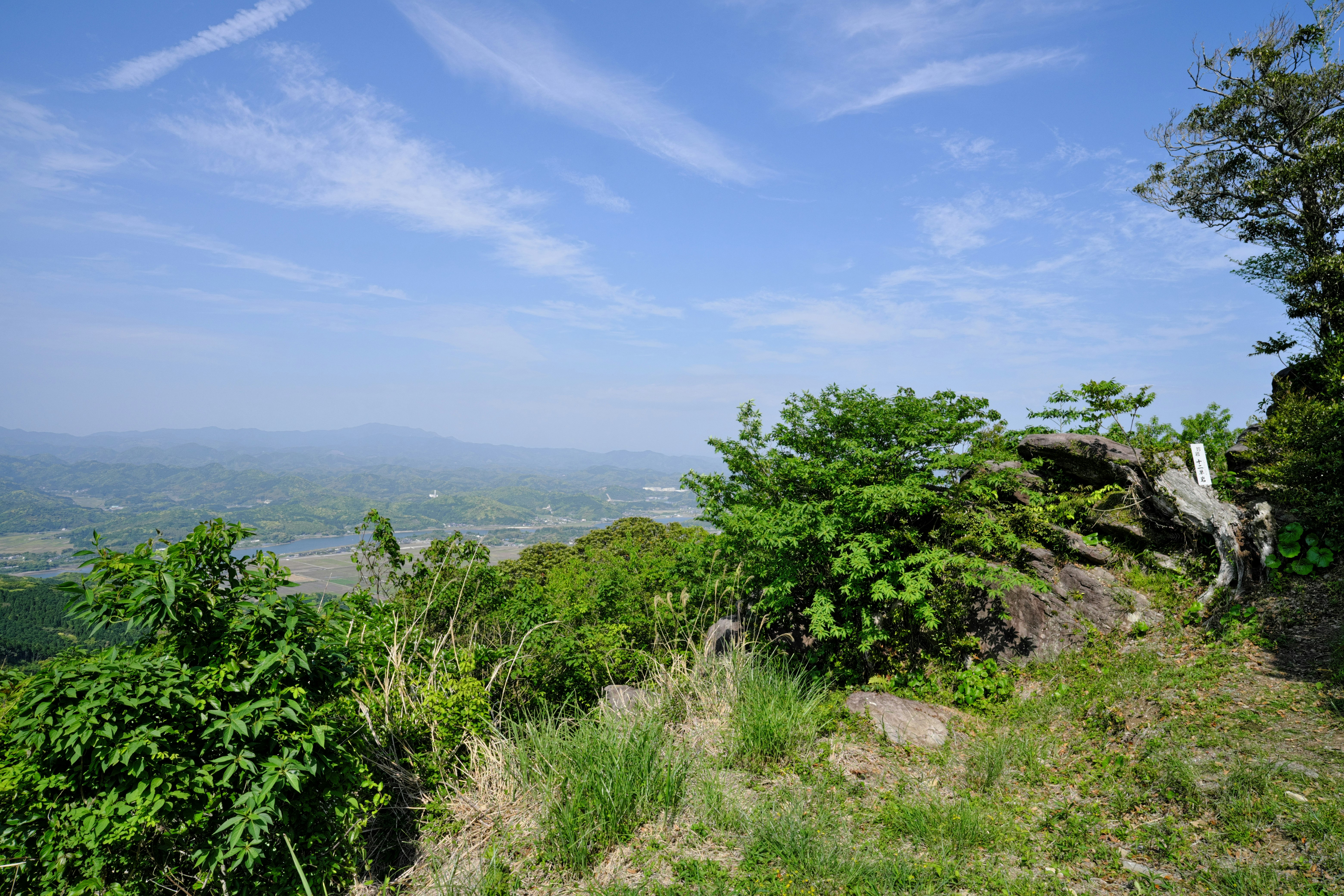 緑の丘陵と遠くまで広がる山並みの展望