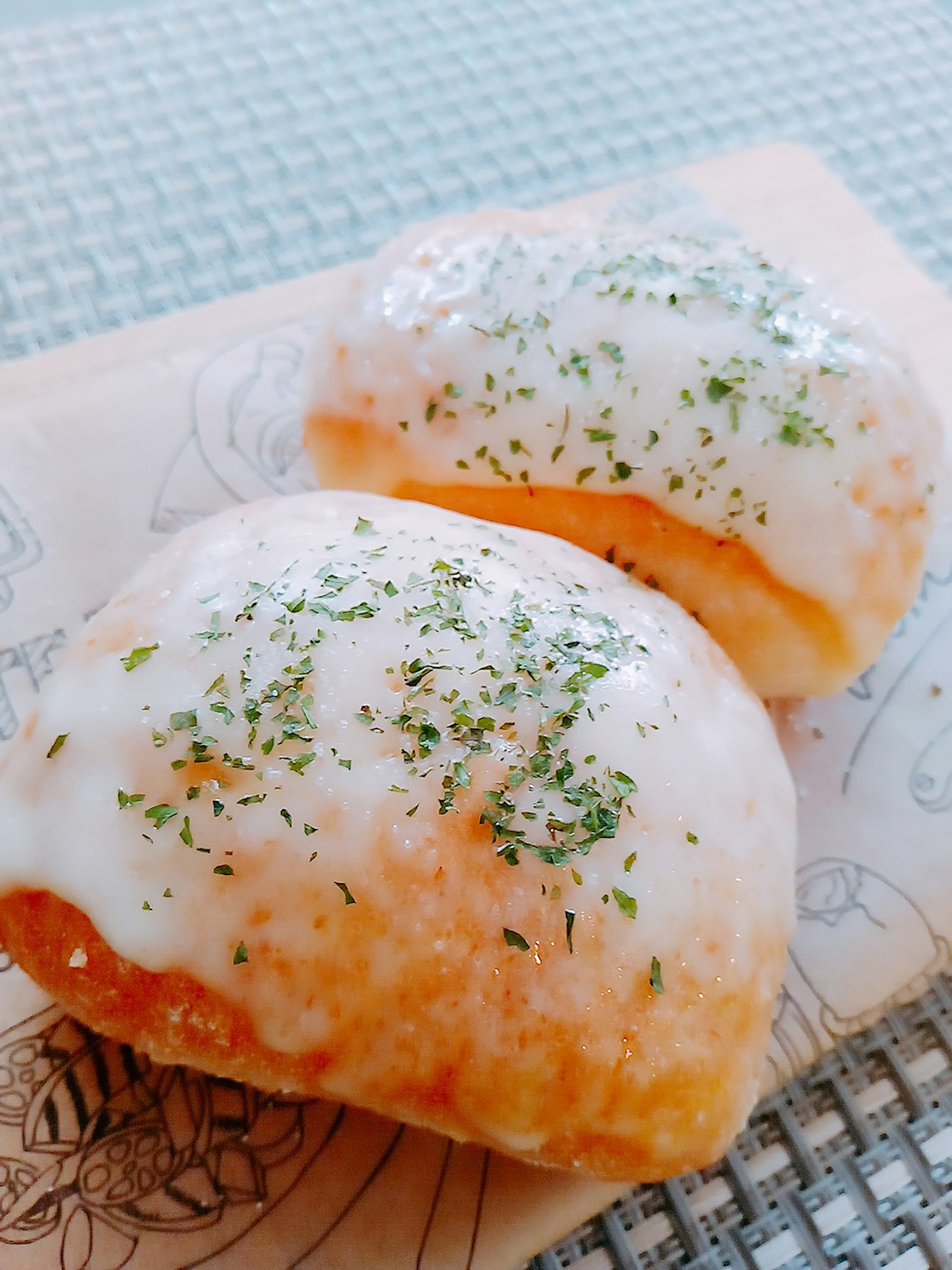 Two creamy buns topped with parsley on a decorative plate
