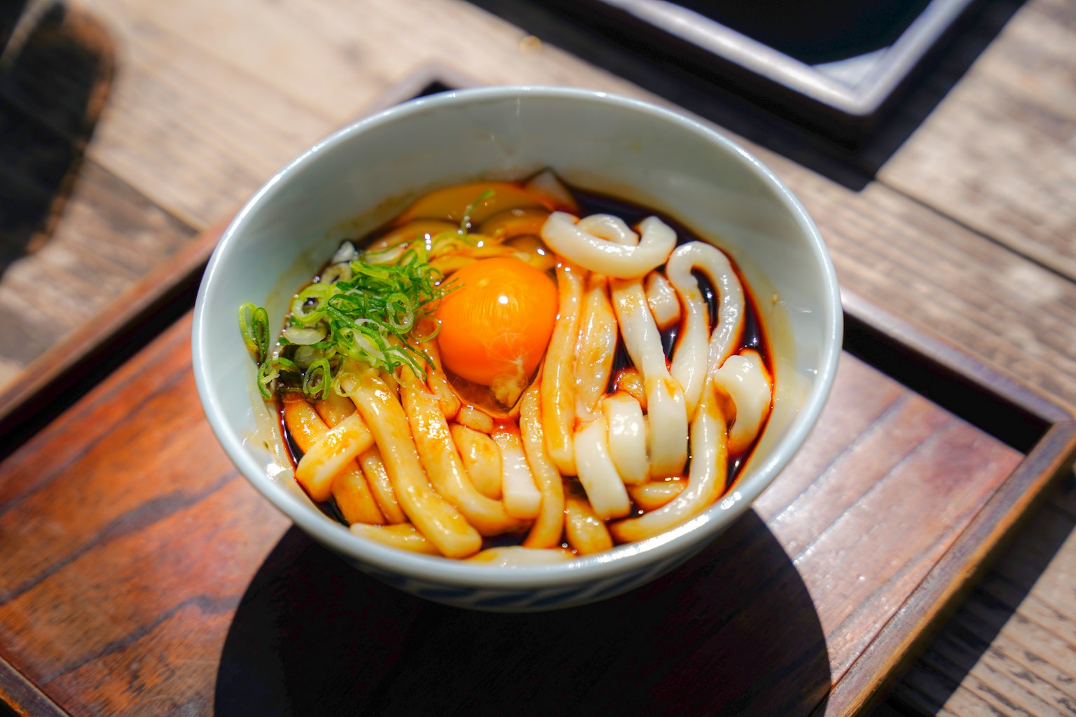 Tazón de udon con huevo crudo y cebollas verdes