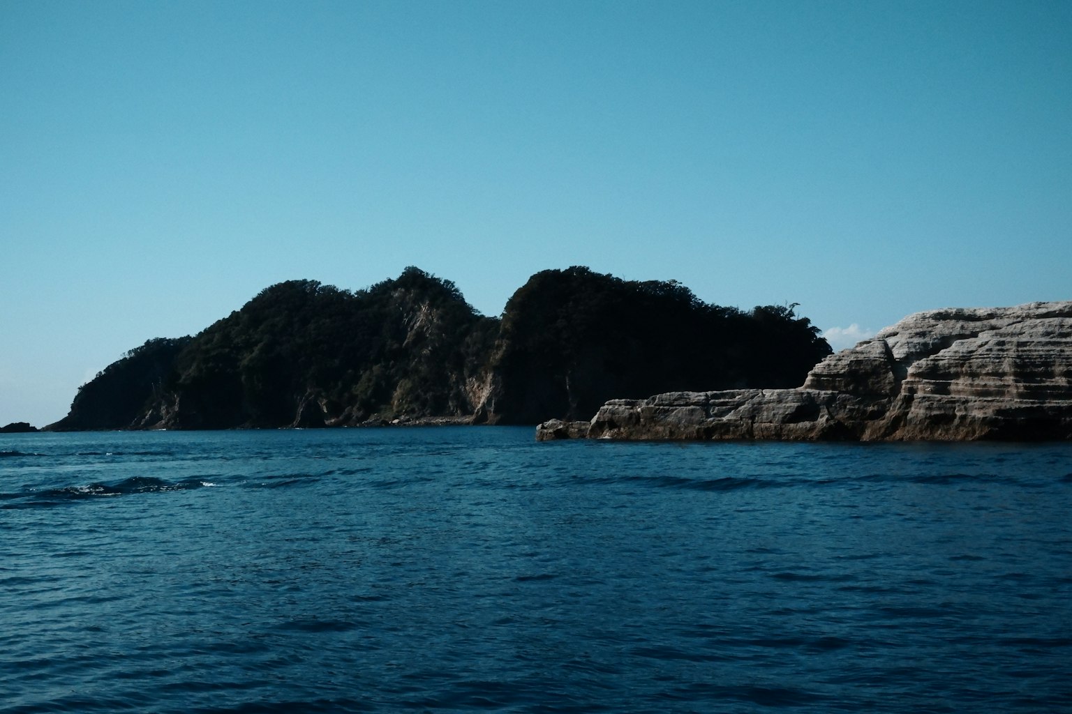 Pemandangan indah pulau dengan pantai berbatu di laut biru