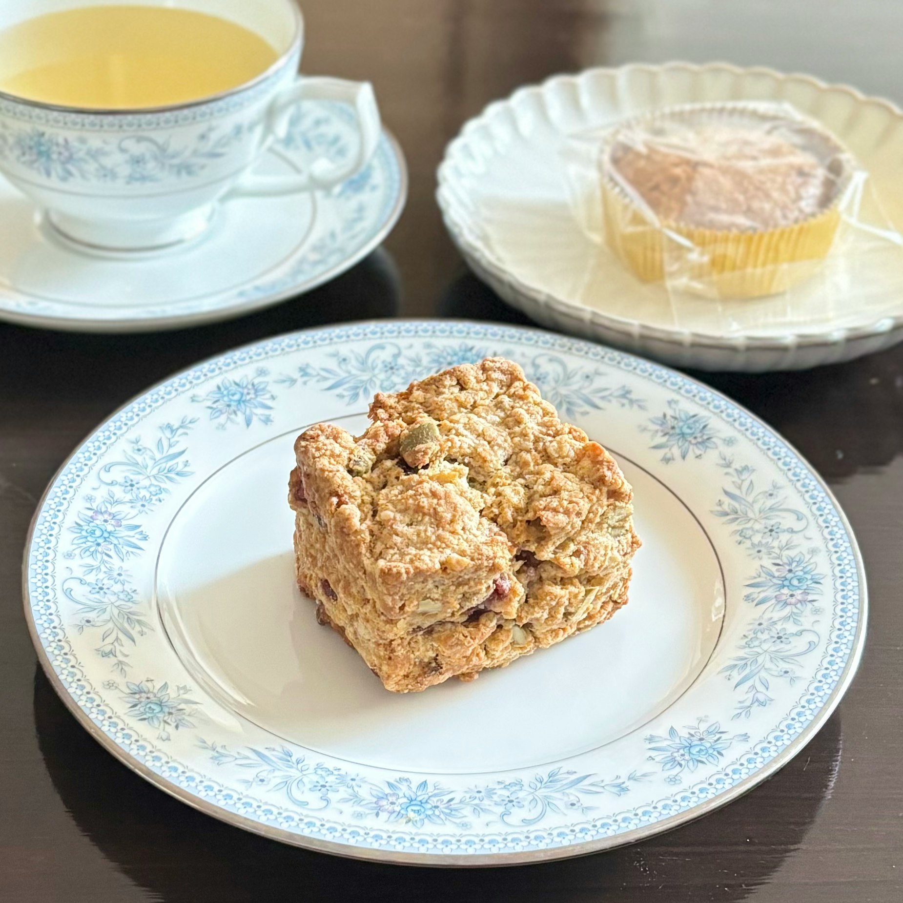 Baked pastry on a blue floral plate with a cup of drink
