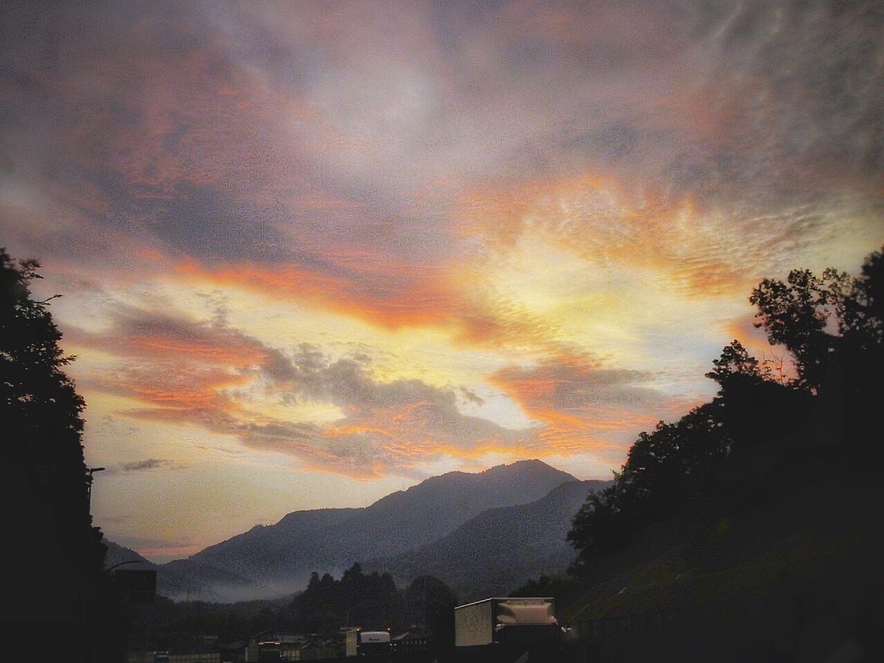 三重県の国道を走行中の夕刻、山並みと夕焼けの空