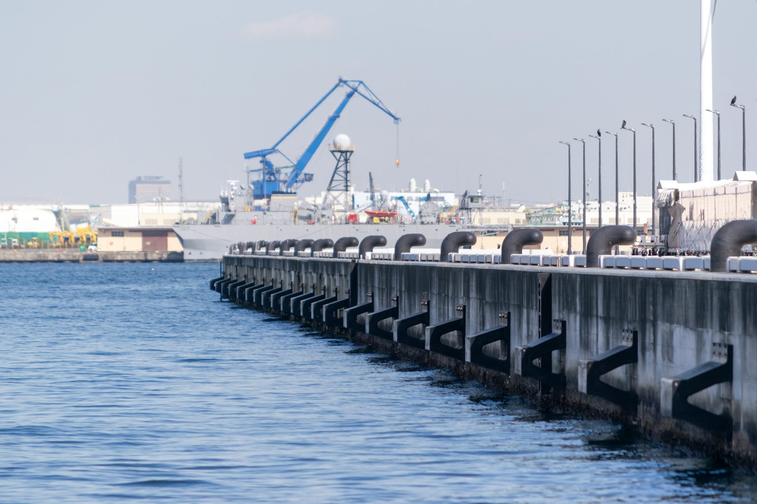 Blick auf einen Hafenpier mit Kränen und Wasser