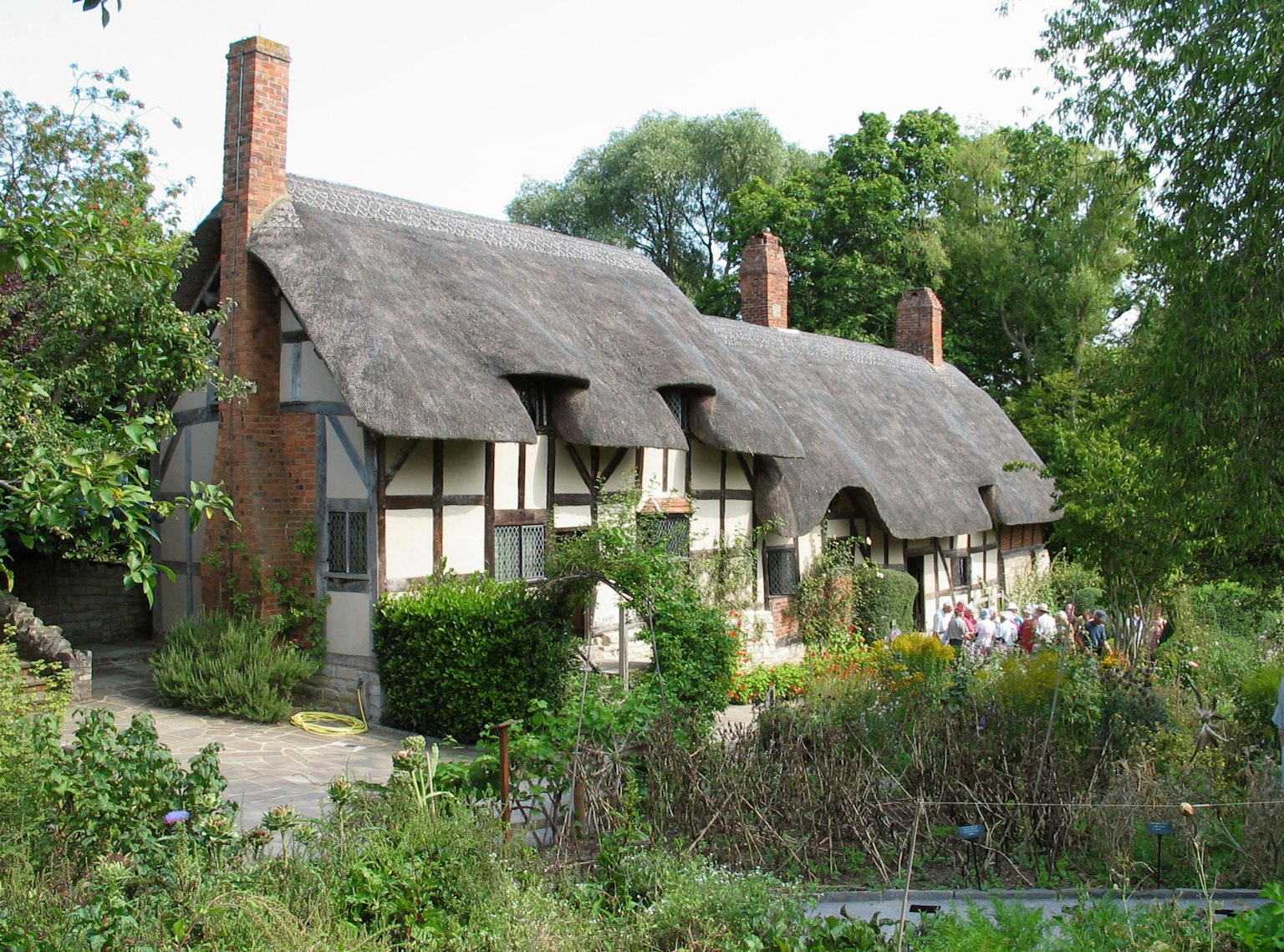 Traditionelles Reetdachhaus mit üppigem Garten