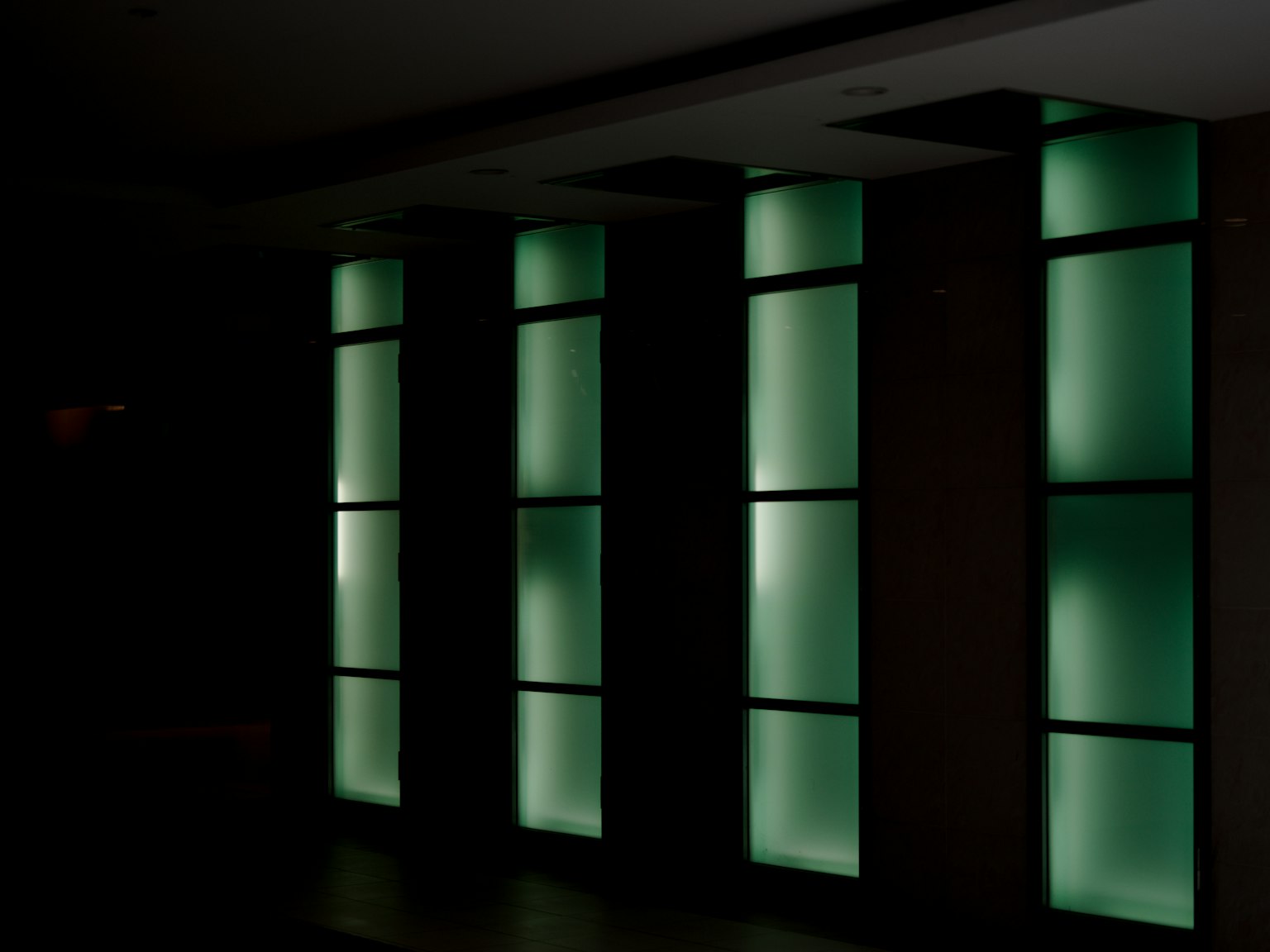 Illuminated columns with green light against a dark background