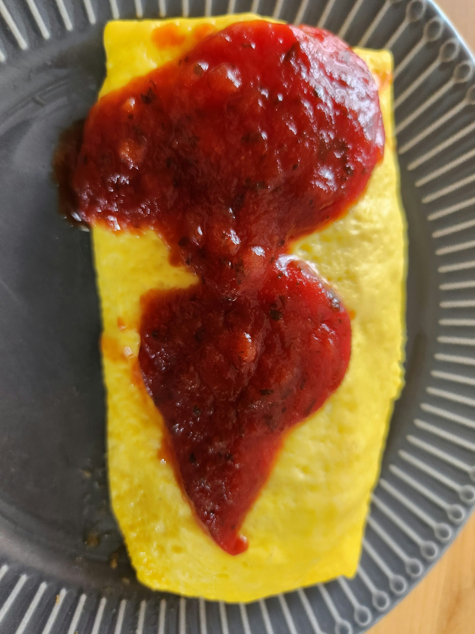 Un piatto di omelette con ketchup sopra