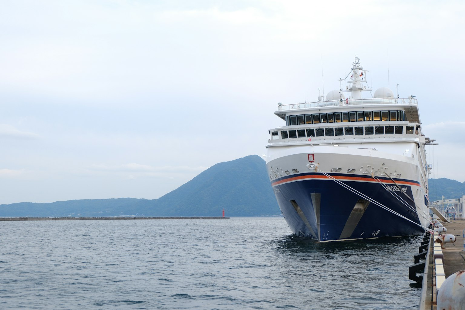 Ferry grande atracado en el agua con fondo montañoso