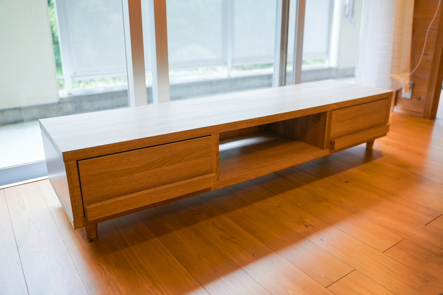 Un mobile TV in legno posizionato in una stanza luminosa