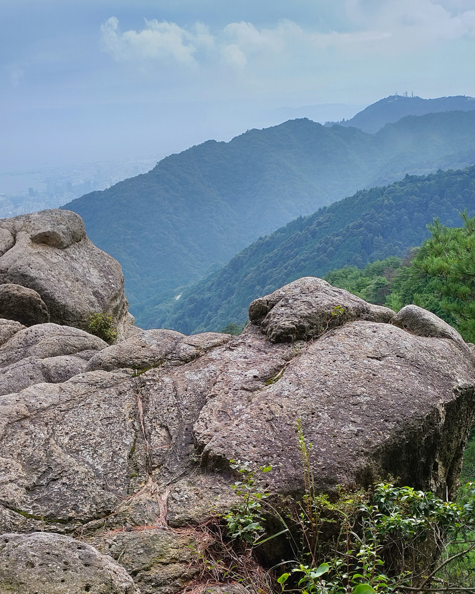 Scenic mountain view with rocky foreground and lush greenery