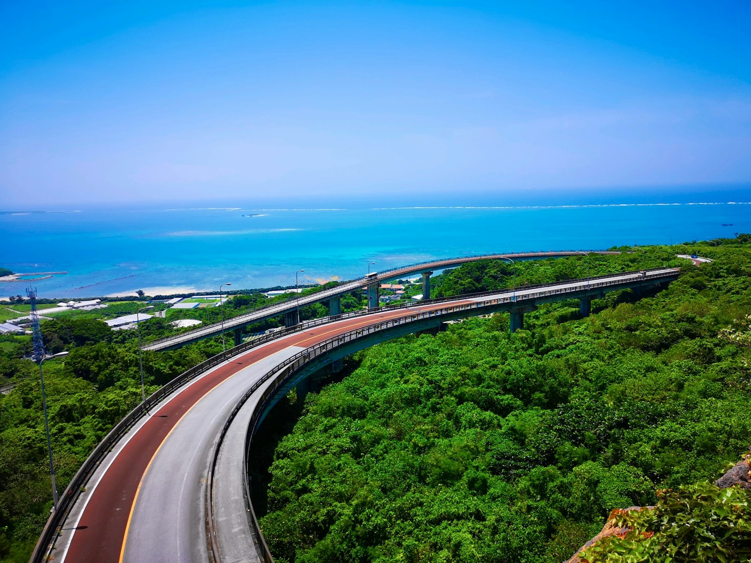 曲折的道路被郁郁葱葱的绿地和蓝色海洋环绕