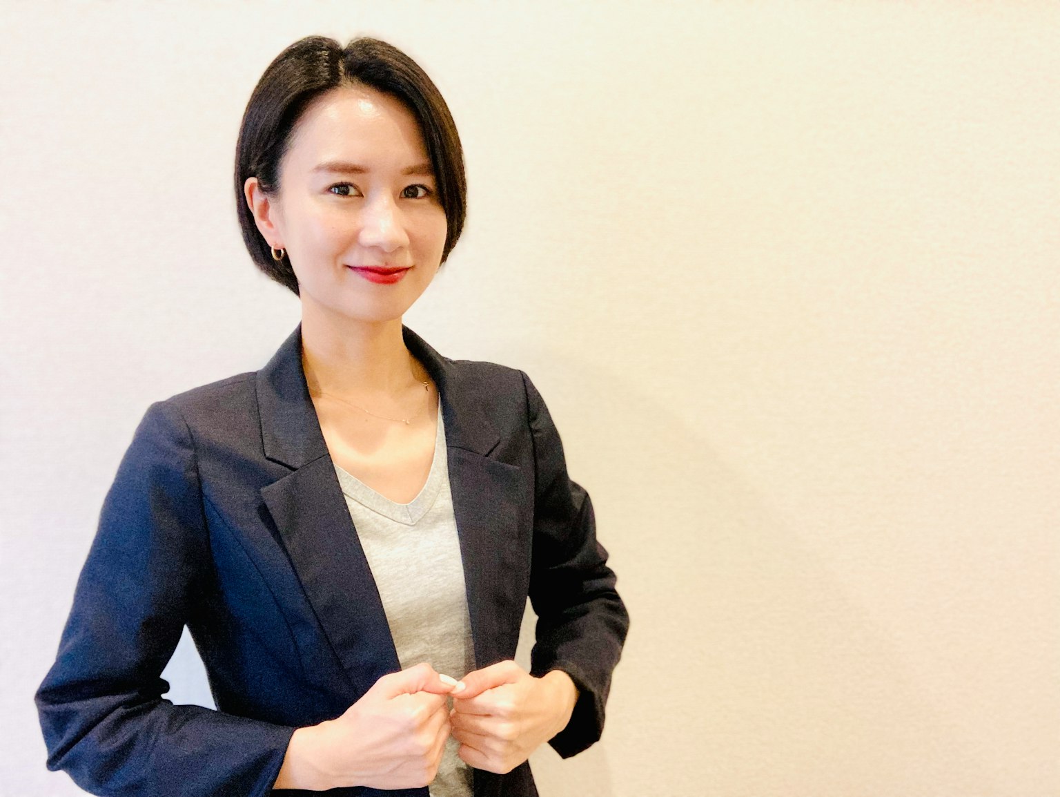 穿着西装的女性在简单背景前微笑