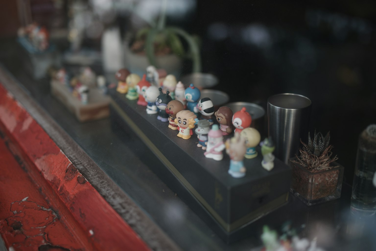 Colorful small figurines lined up in a shop window display