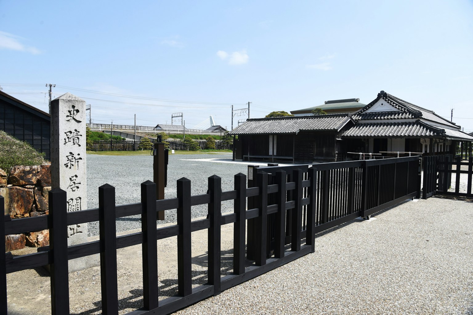 Rumah tradisional Jepang dengan pagar hitam dan latar belakang pemandangan