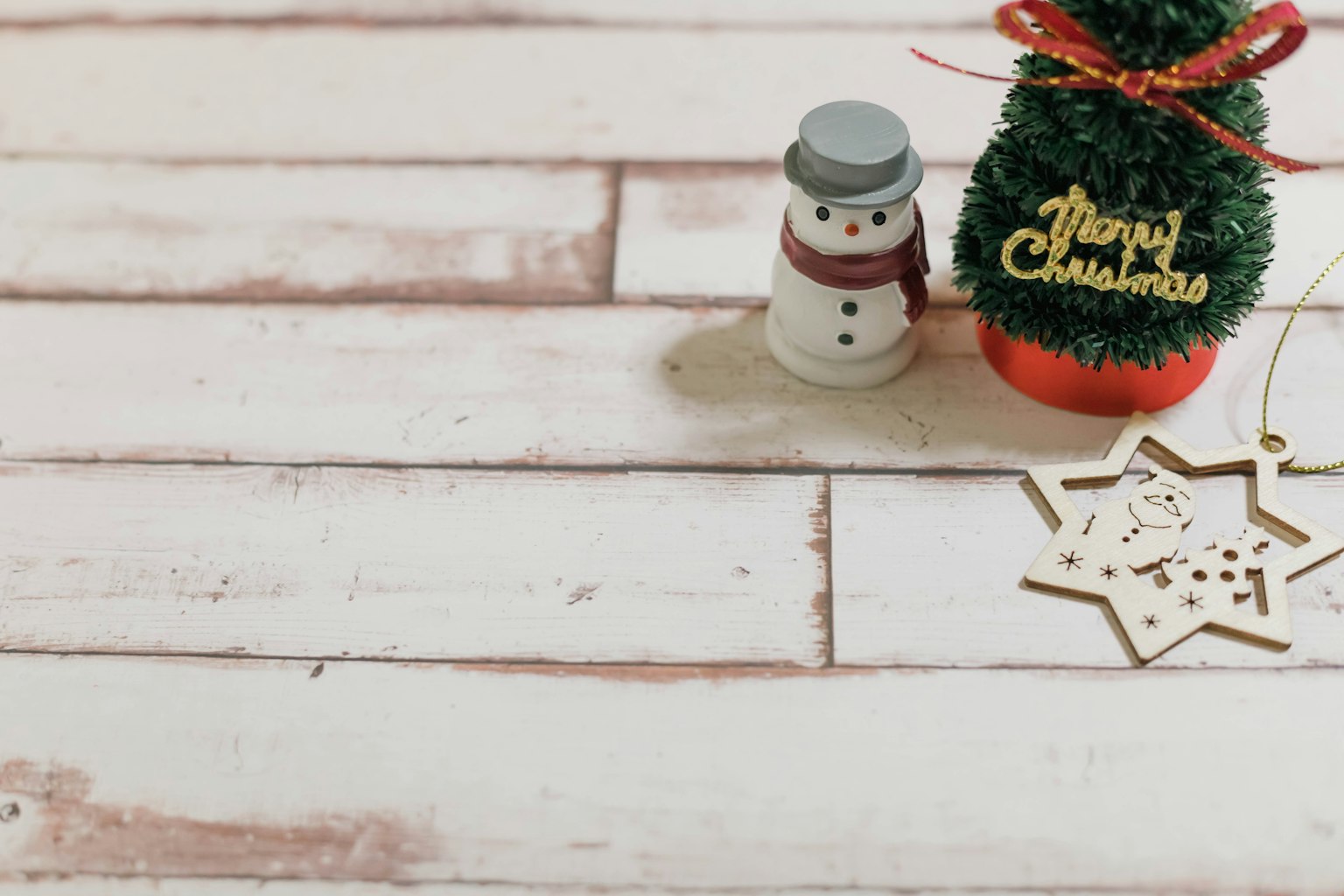 Boneka salju kecil dan dekorasi Natal di atas permukaan kayu putih