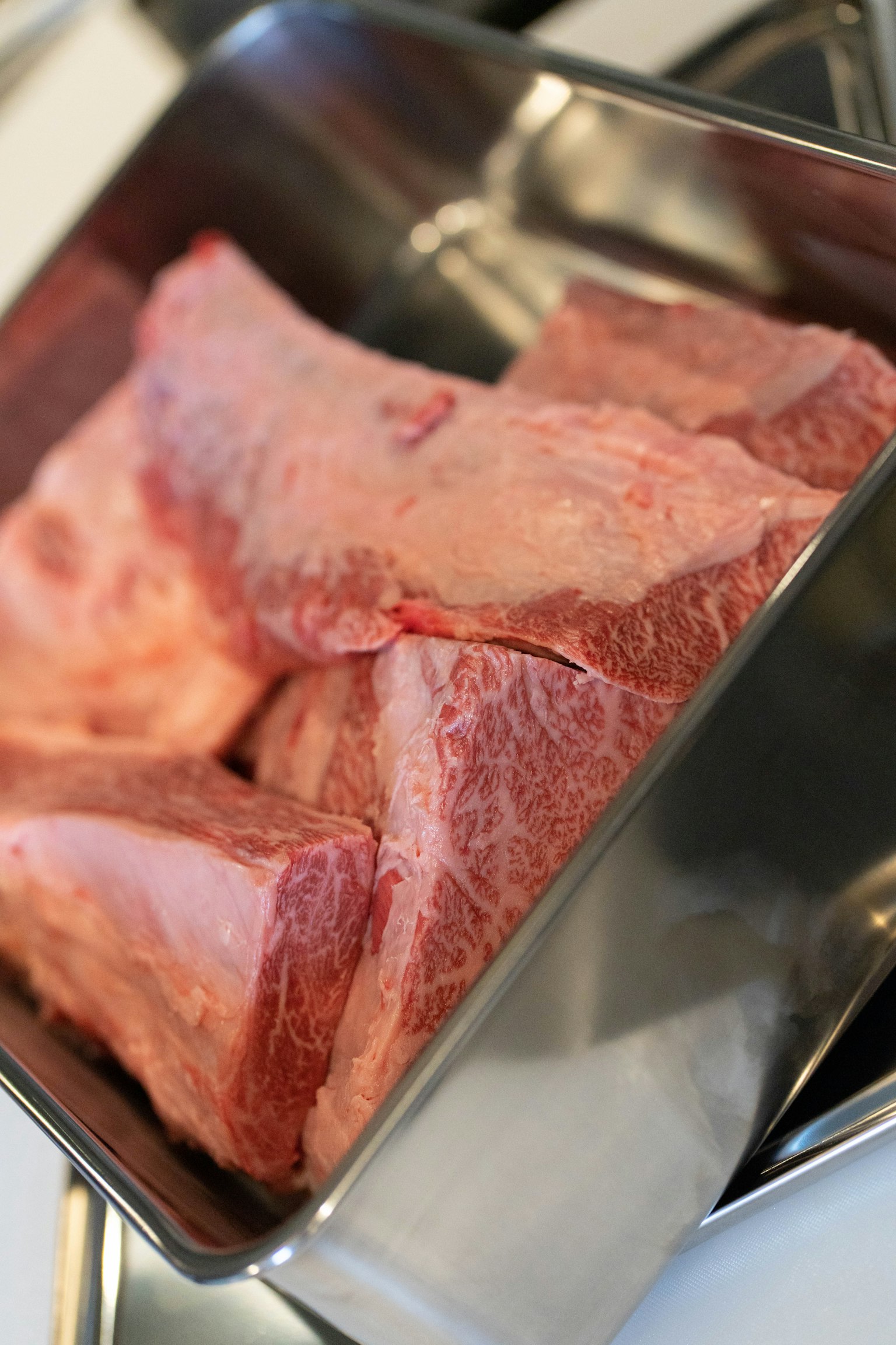 Chunks of raw meat in a stainless steel pot