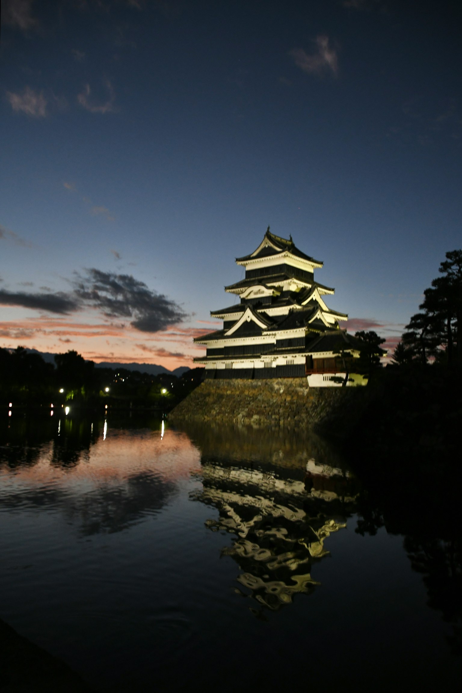 Castello di Matsumoto illuminato di notte con riflesso nell'acqua