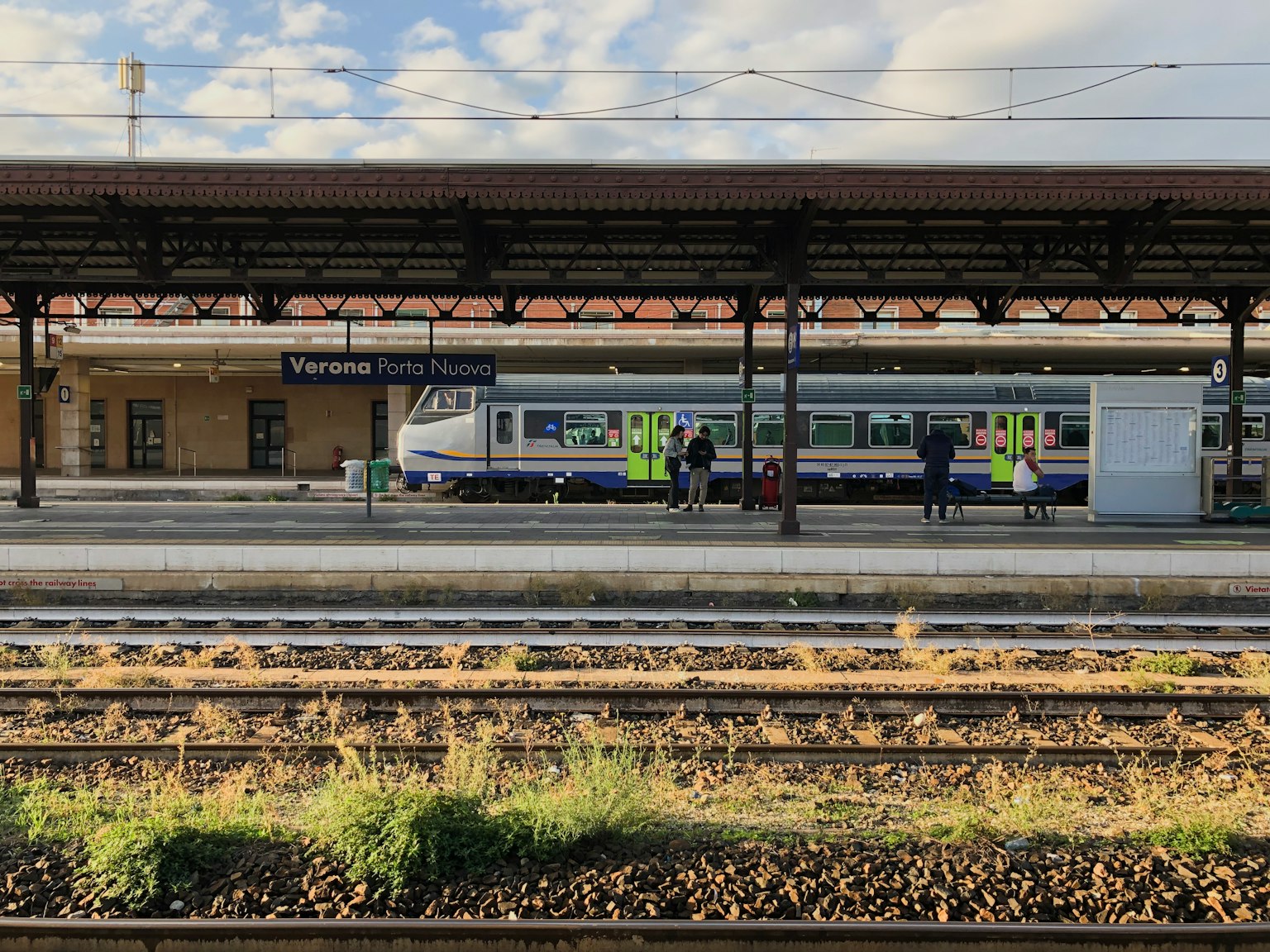 Pemandangan kereta di peron dengan bangunan stasiun