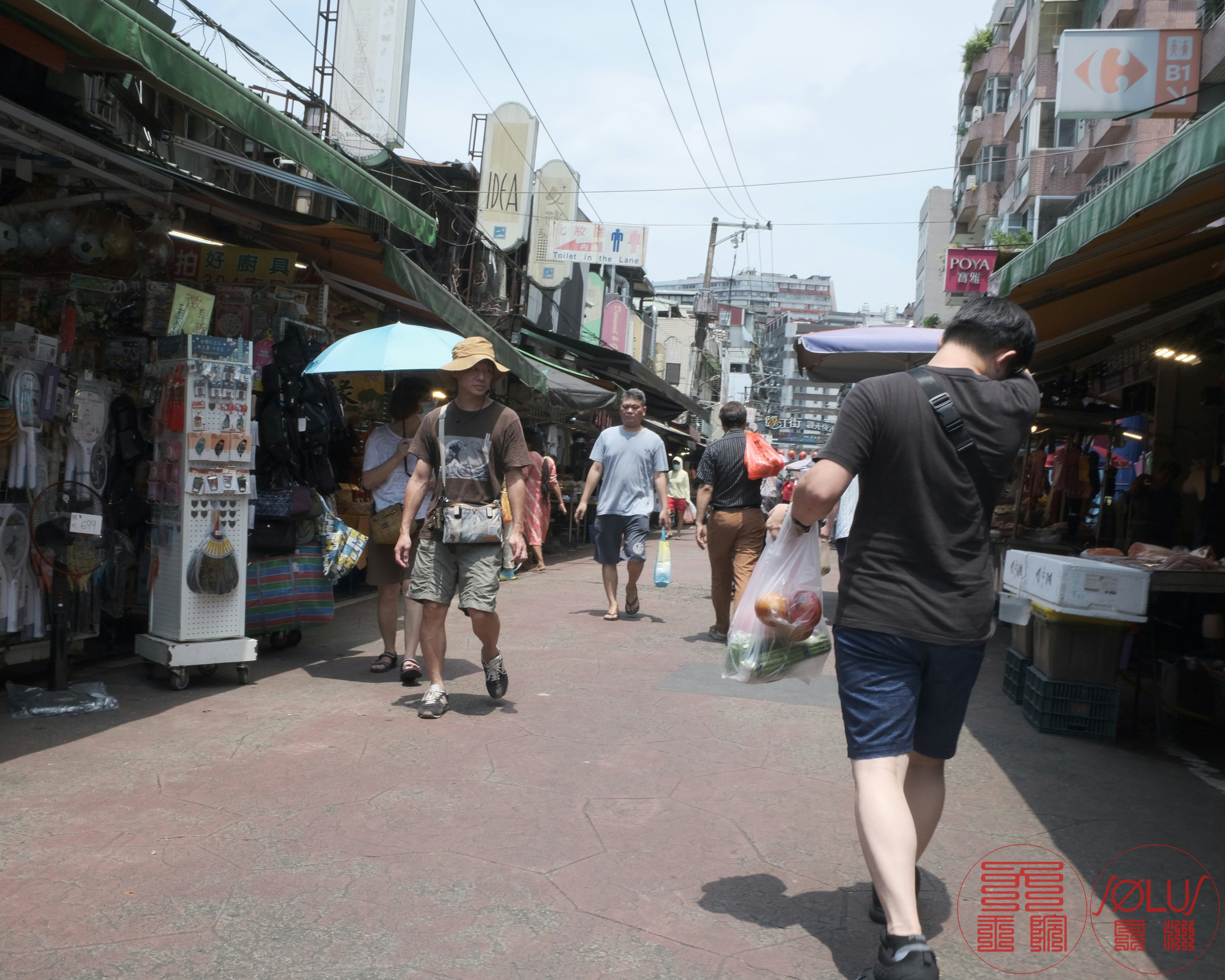 Des personnes marchent dans une rue de marché couverte à Taipei