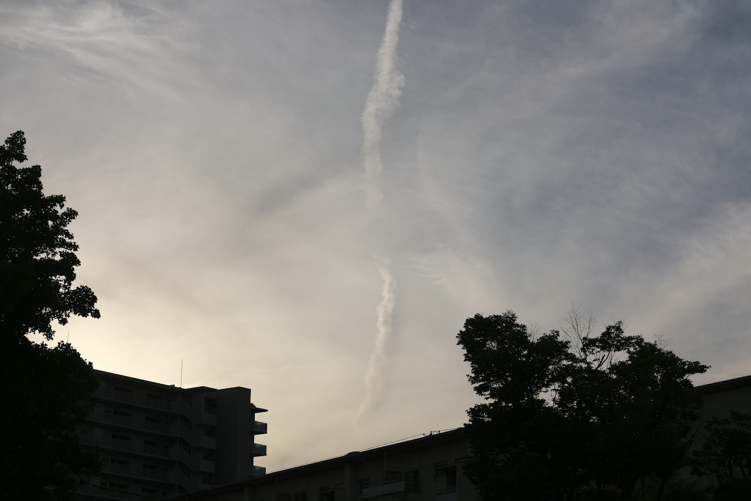 Una striscia di nuvola nel cielo con sagome di edifici
