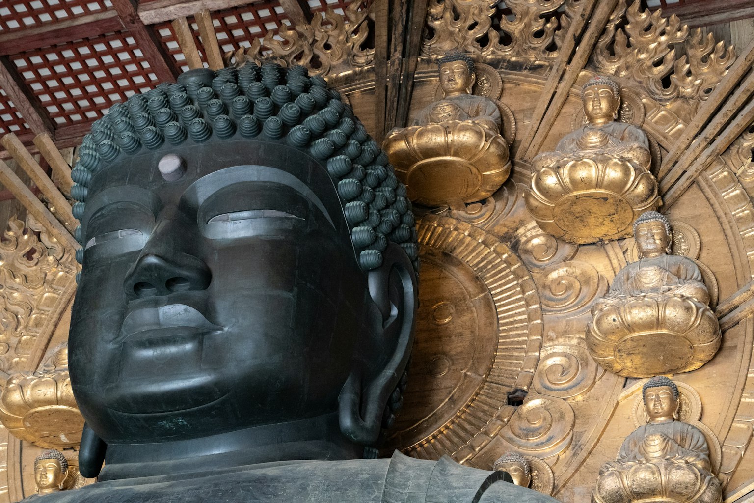 Gros plan d'une statue de Bouddha avec des figures dorées en arrière-plan
