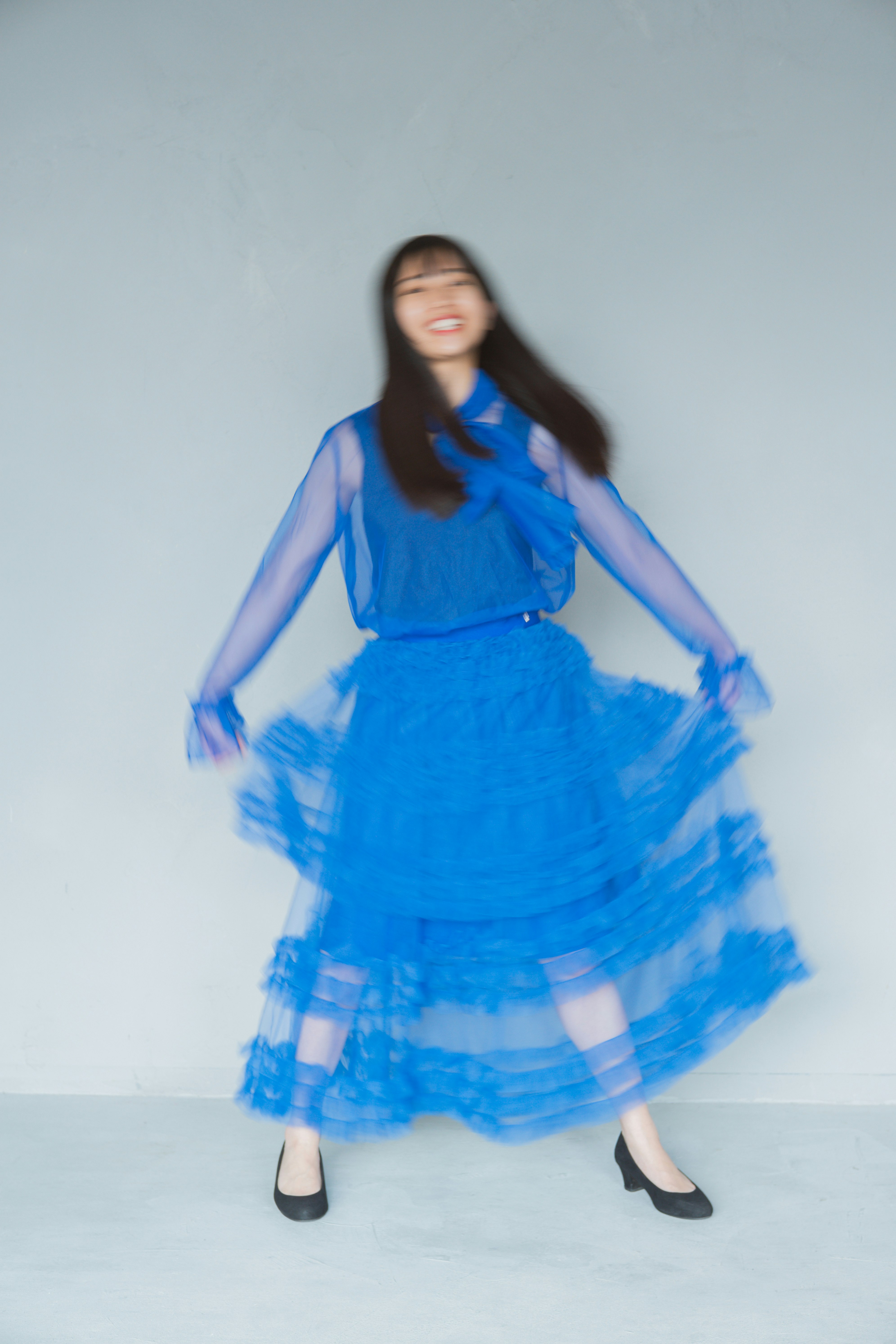 Studio-Pose einer Frau im blauen Kleid