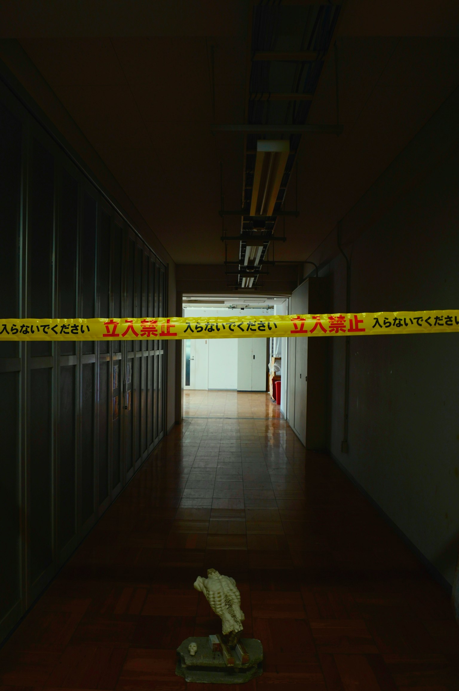 Sebuah lorong dengan pita peringatan dan objek putih di lantai