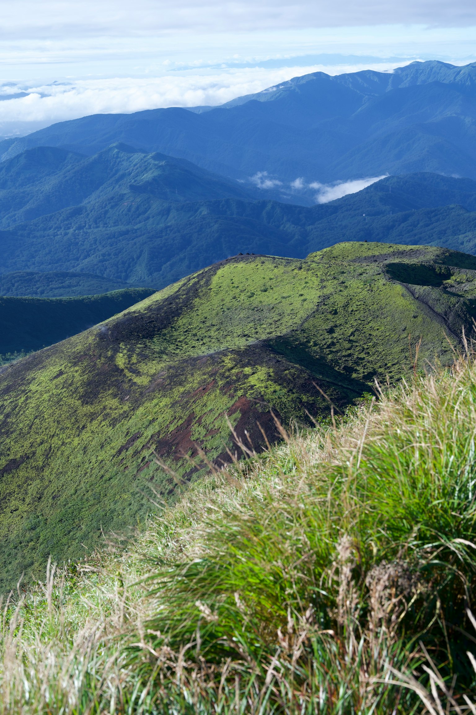 Pemandangan indah perbukitan hijau dan gunung jauh