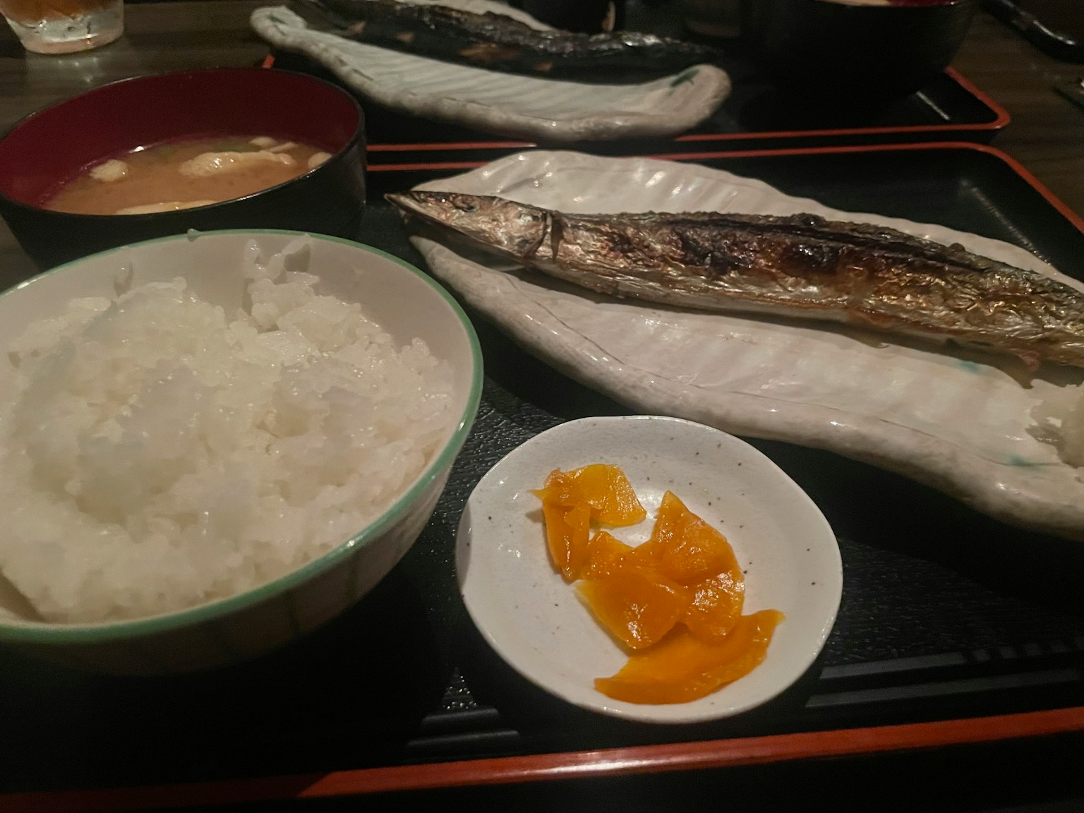 白い皿に盛られた焼き魚とご飯、味噌汁と漬物のセット