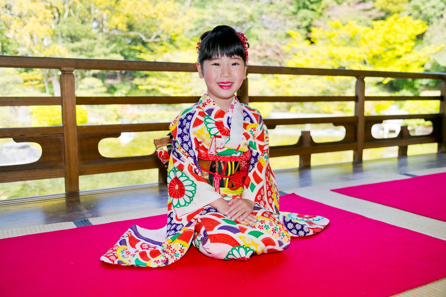 Ein Mädchen in einem lebhaften Kimono sitzt in einer traditionellen japanischen Umgebung
