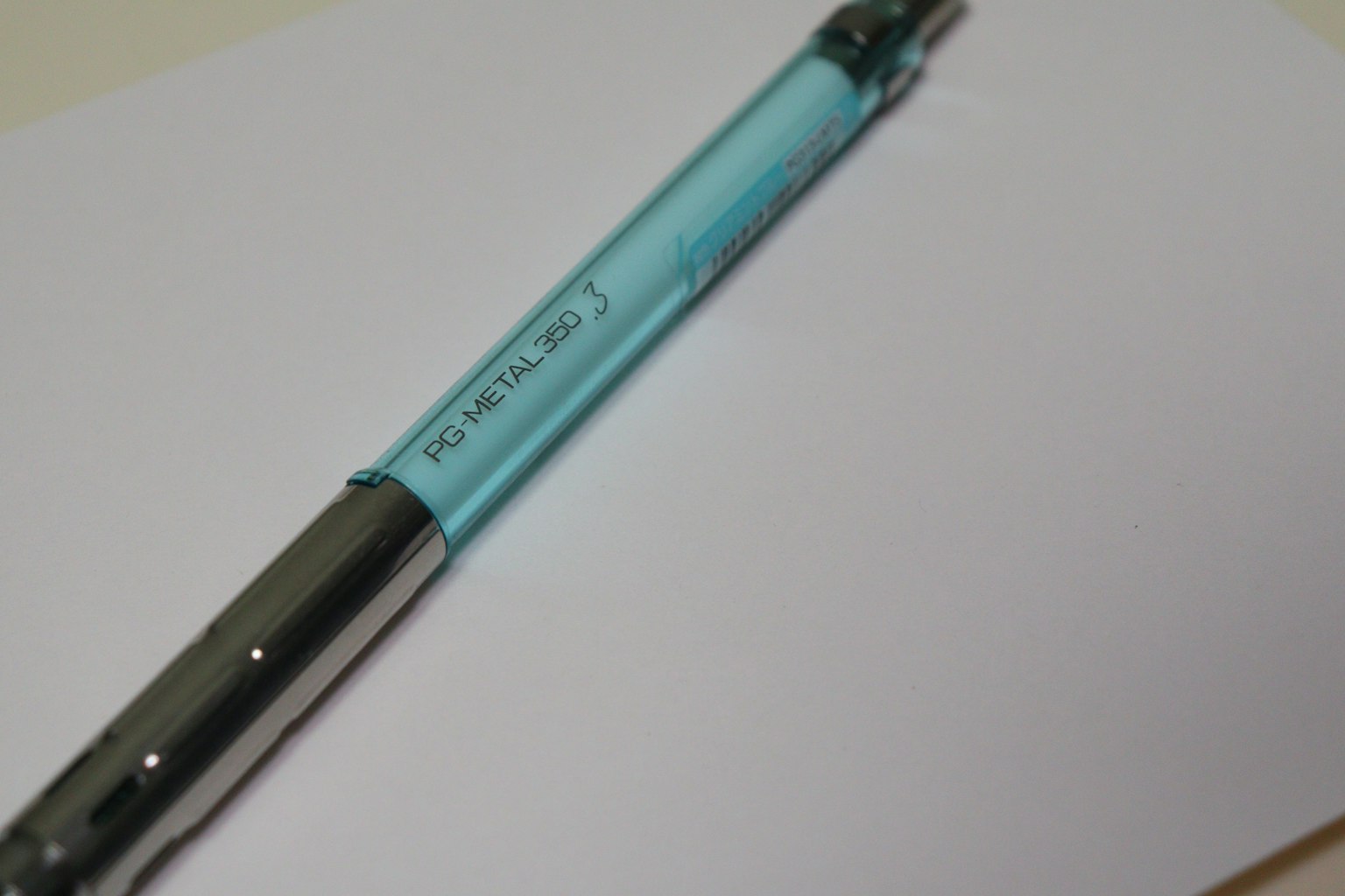 A blue ballpoint pen resting on a sheet of white paper