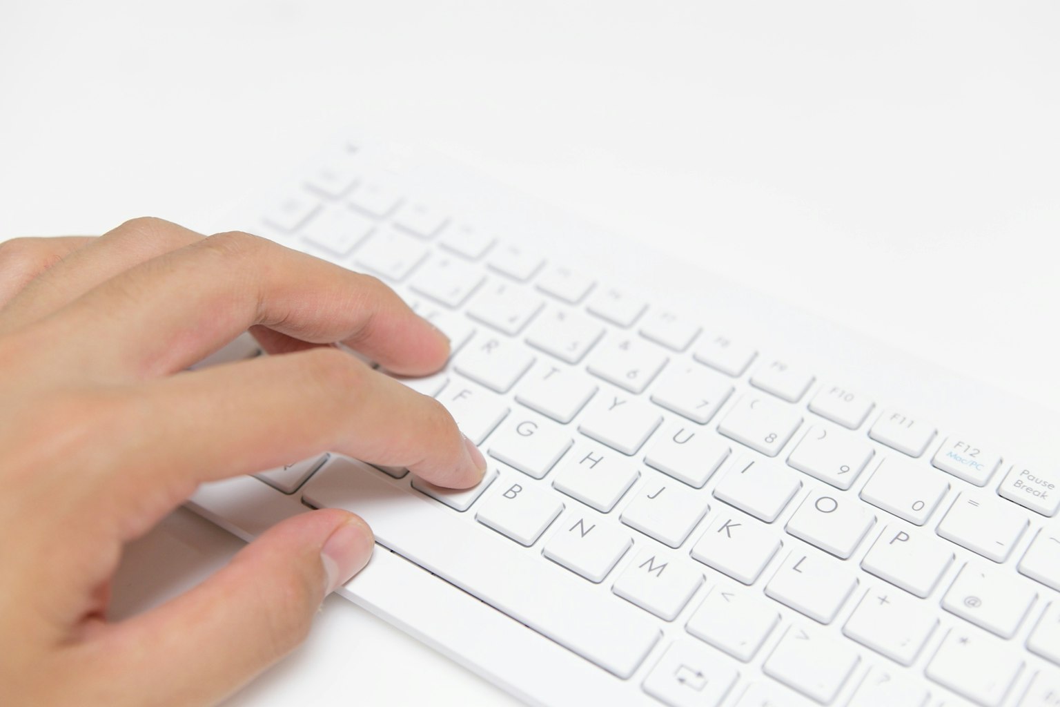 Una mano sobre un teclado blanco