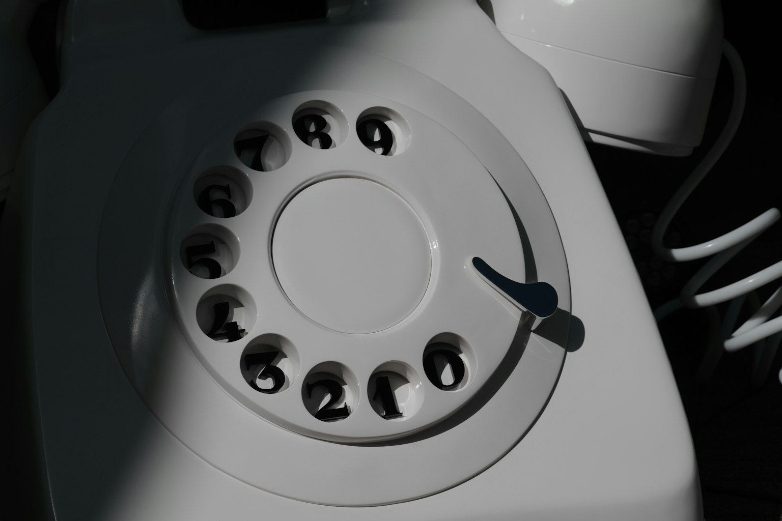 Close-up of a vintage white rotary telephone dial