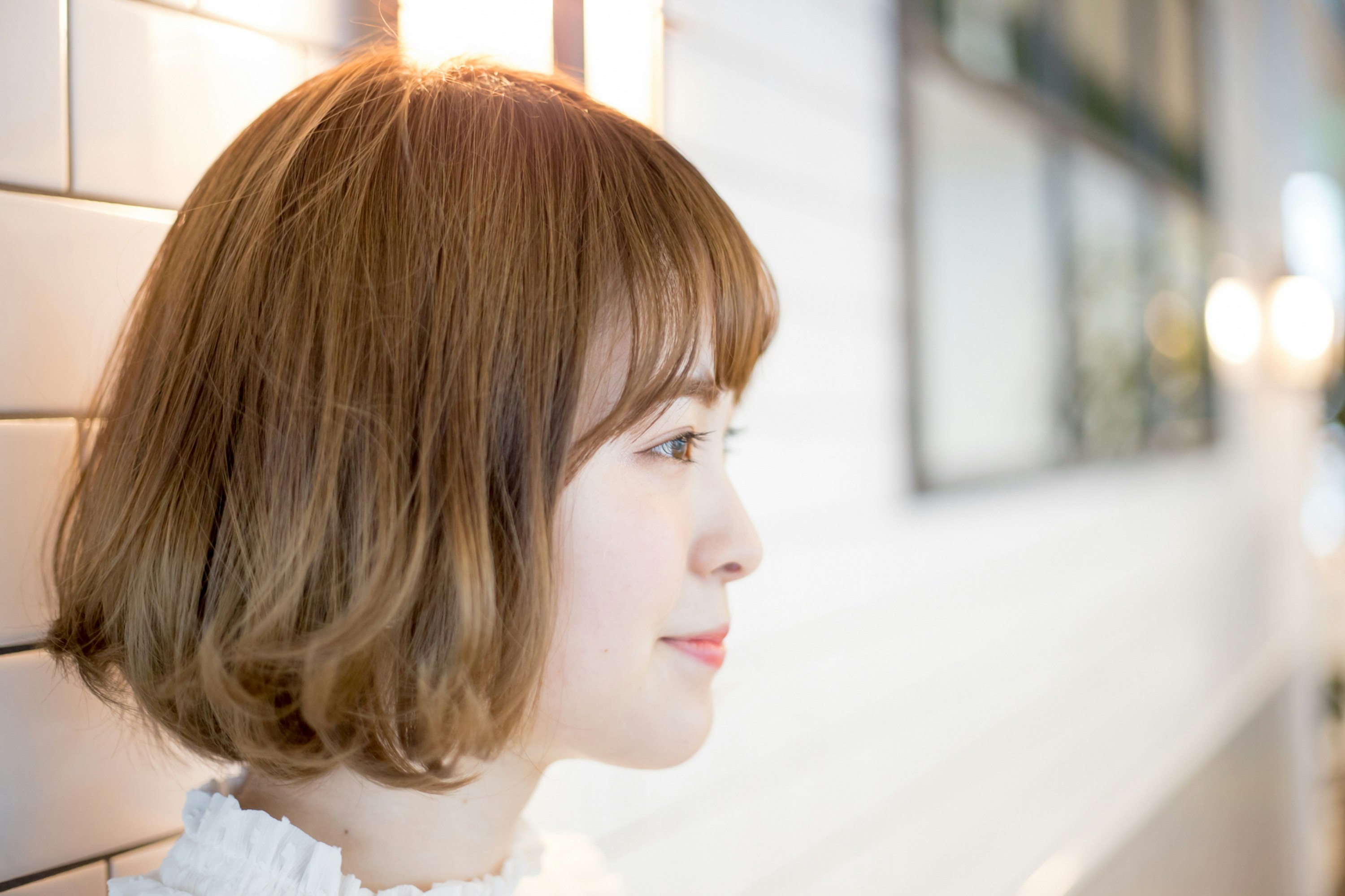 窓辺に寄りかかる横顔の女性
