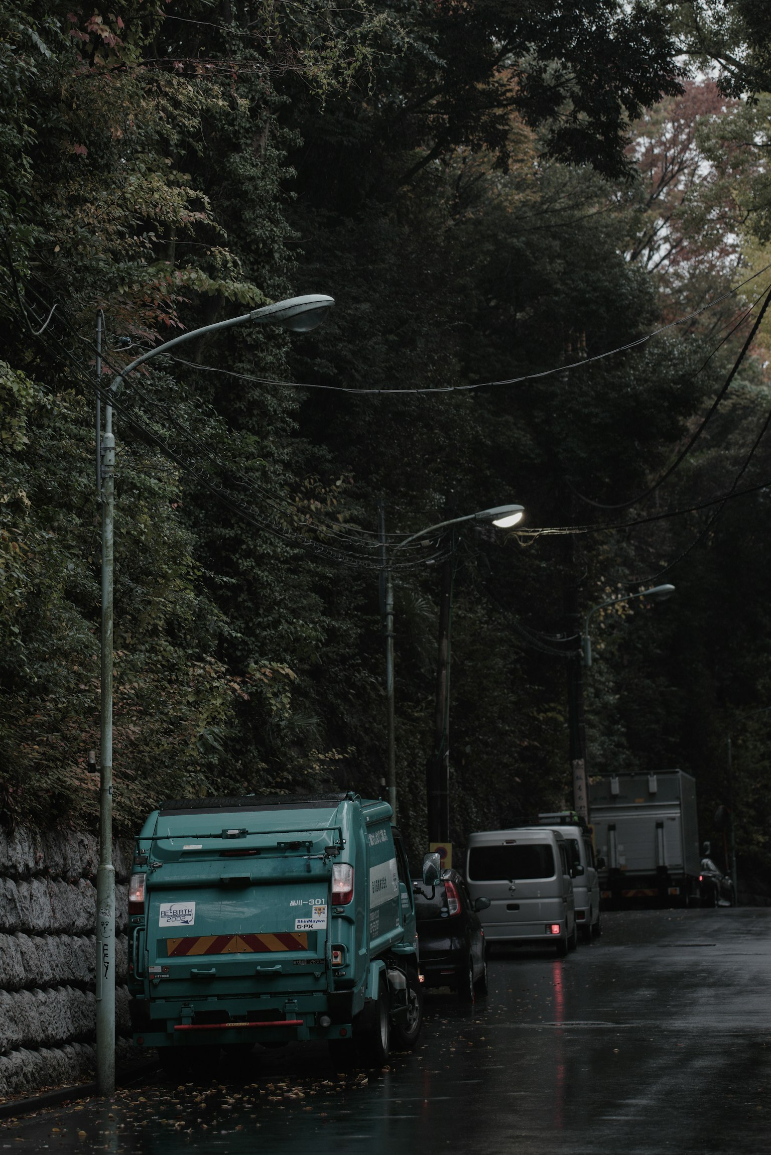 Scena di strada tranquilla con un camion della spazzatura verde e lampioni