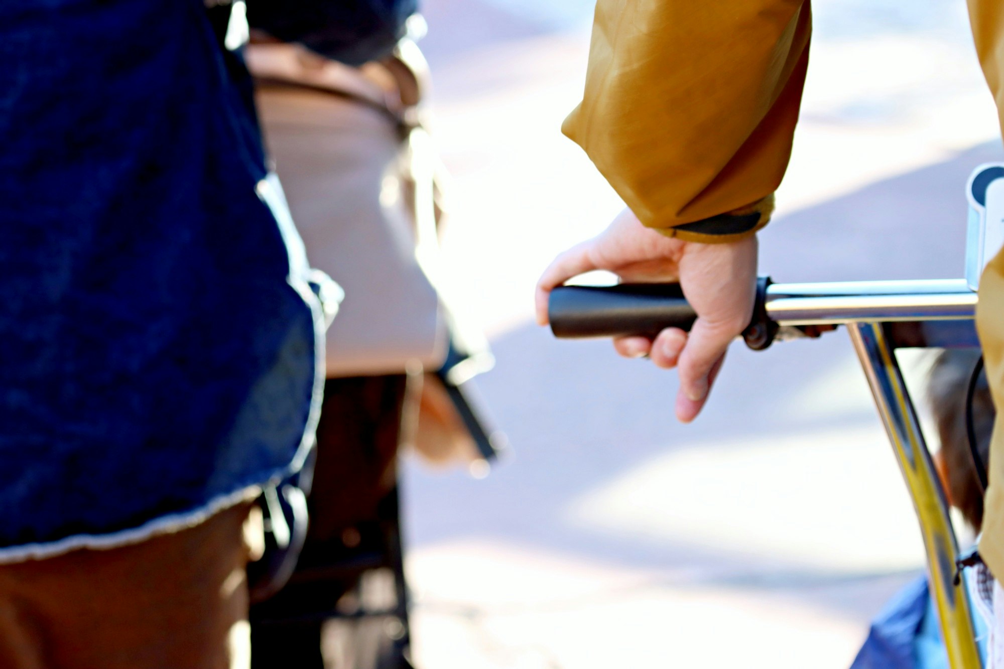 person holding a bicycle handlebar with pedestrians in the street