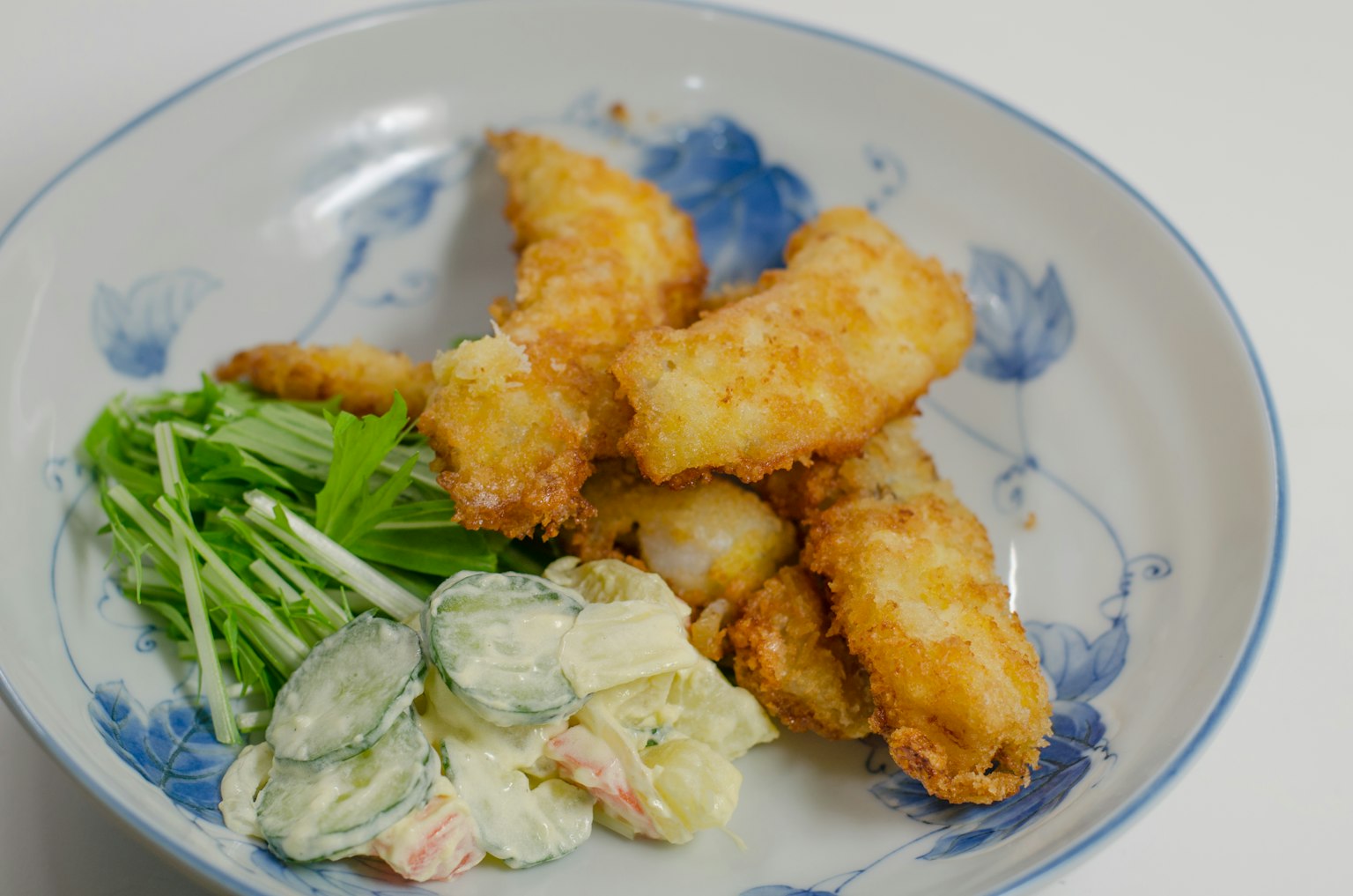 Filetti di pesce fritti serviti con insalata e verdure